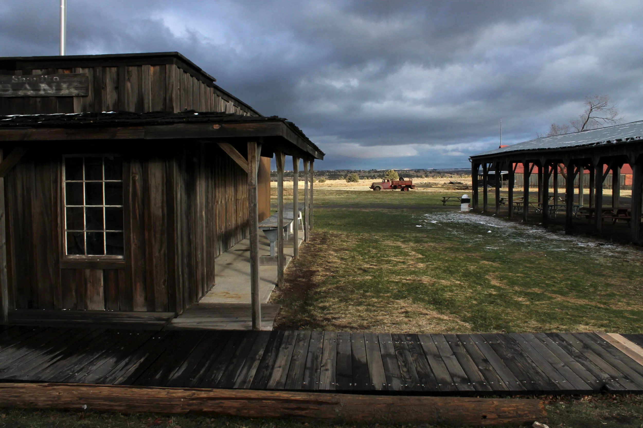 Dramatic clouds over old buildings and truck in Shaniko Oregon