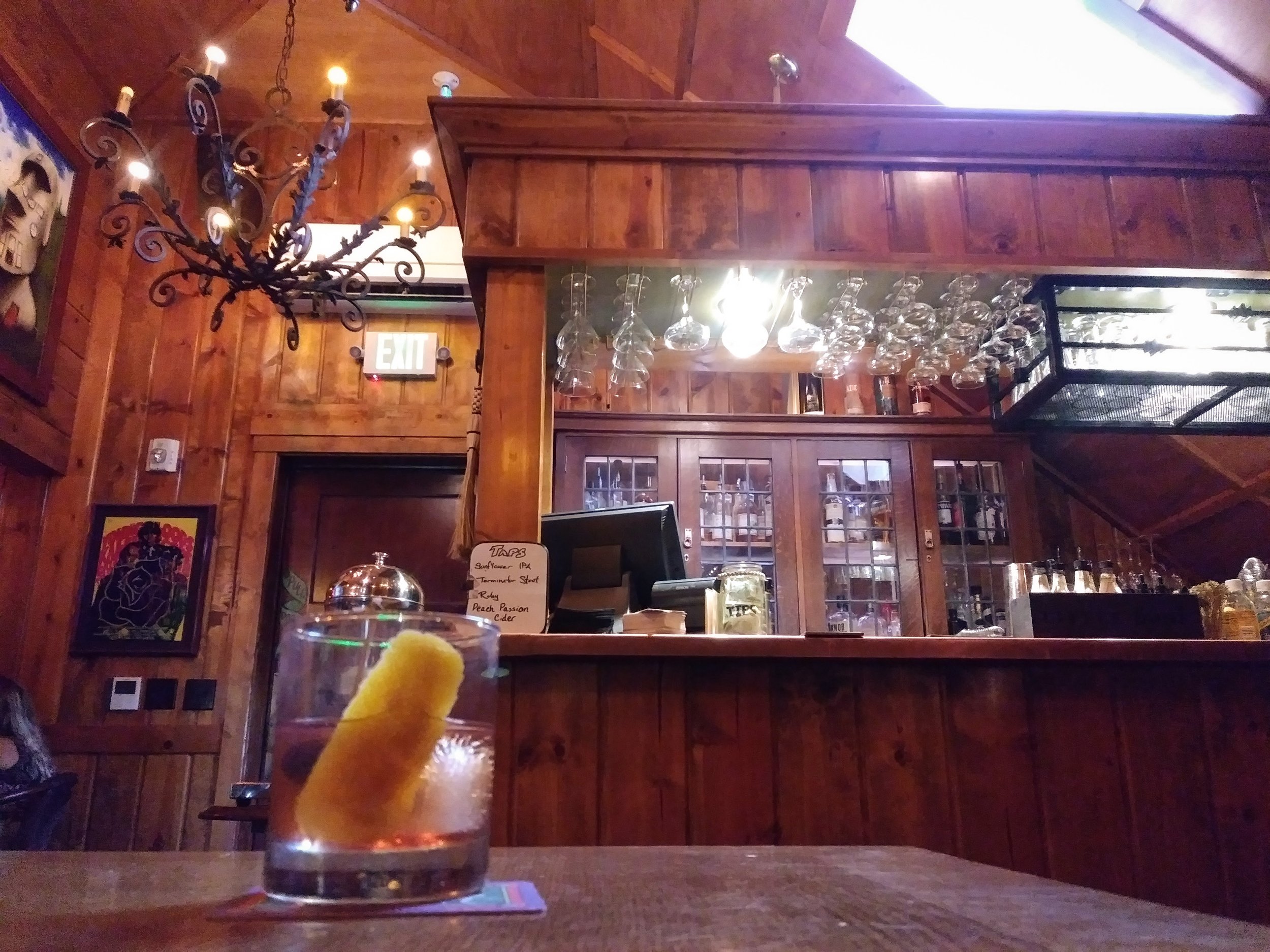 Old fashioned on table in front of wood paneled bar