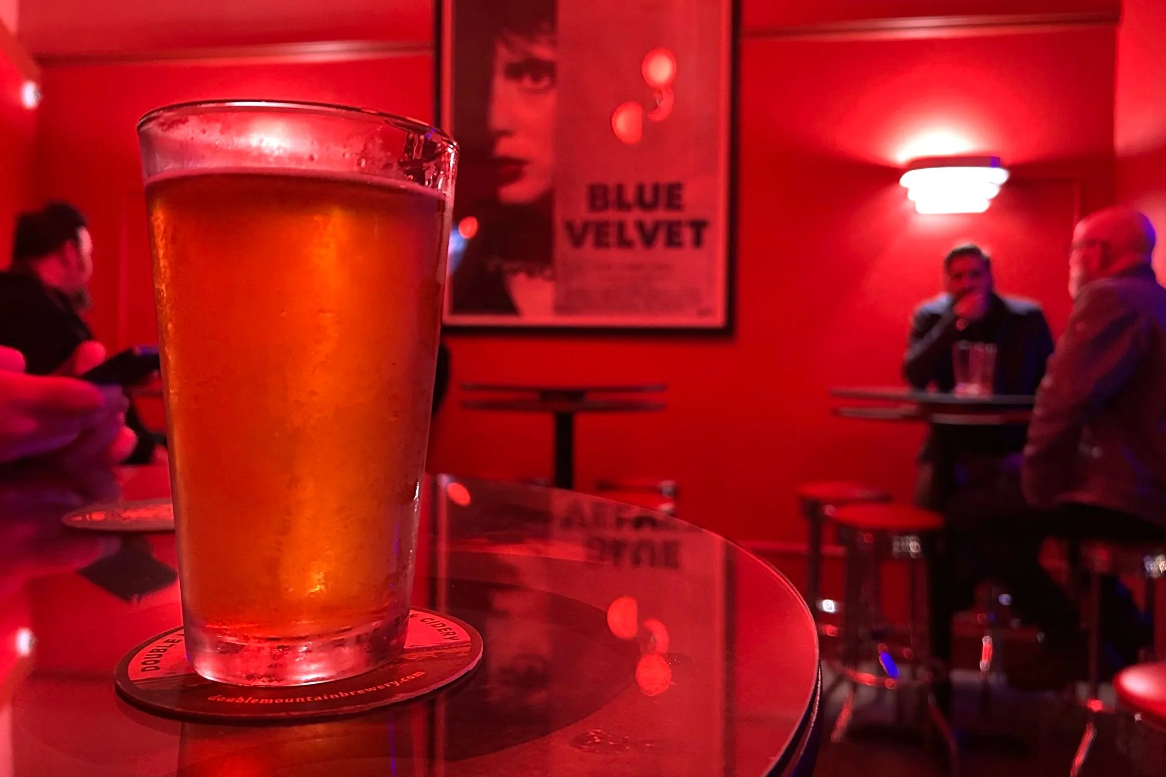 Beer in a red lit bar with Blue Velvet poster