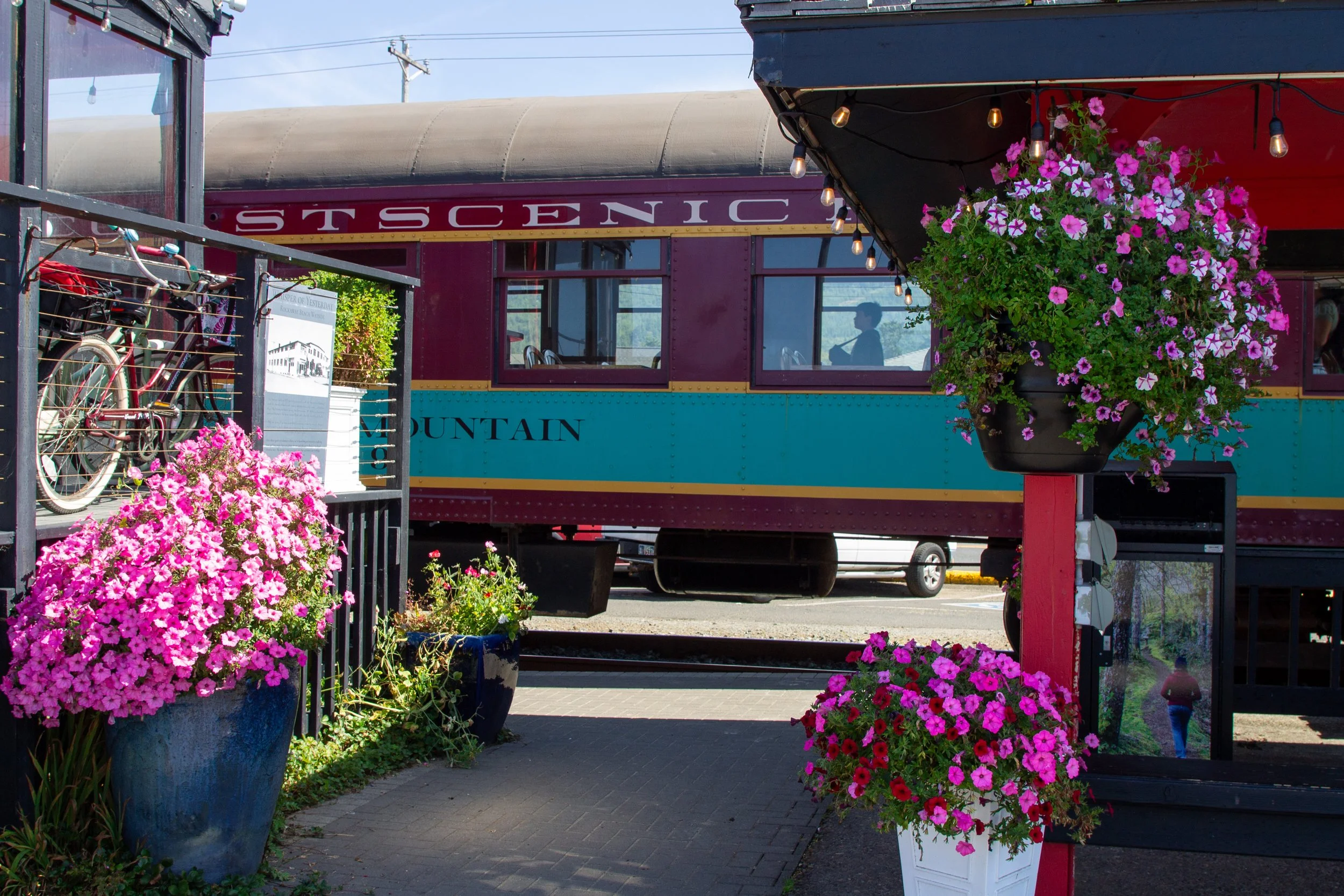 Hanging baskets at train platform with vintage train
