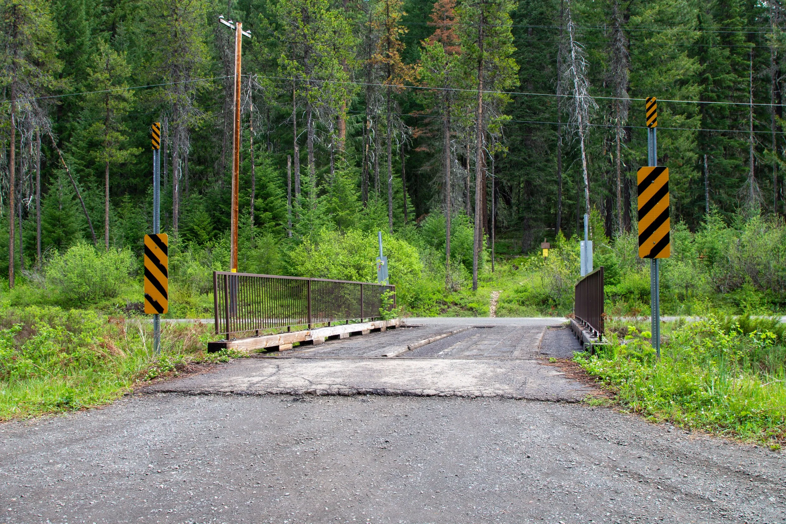 Small bridge connects paved and gravel roads