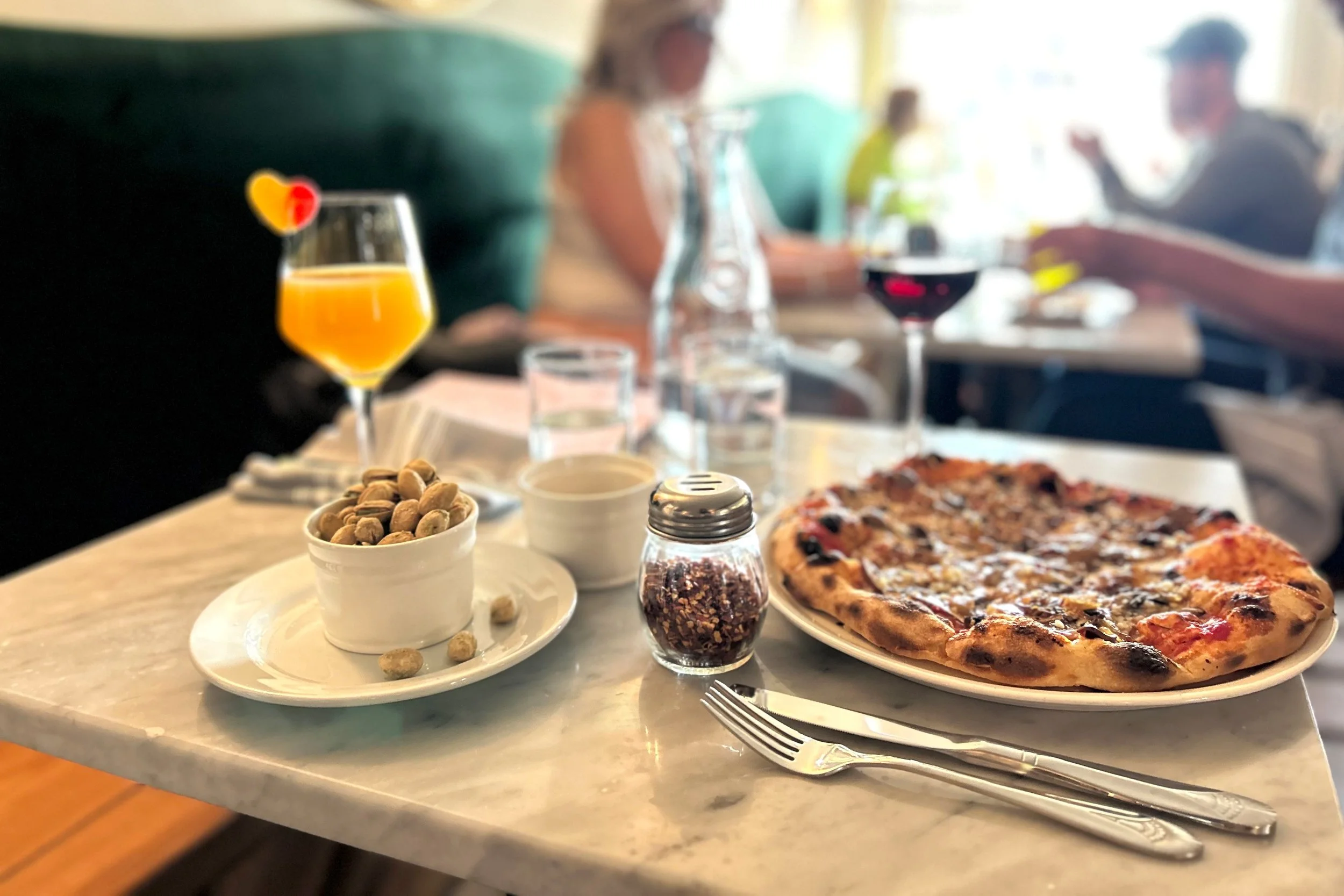 Table in restaurant with drinks and pizza