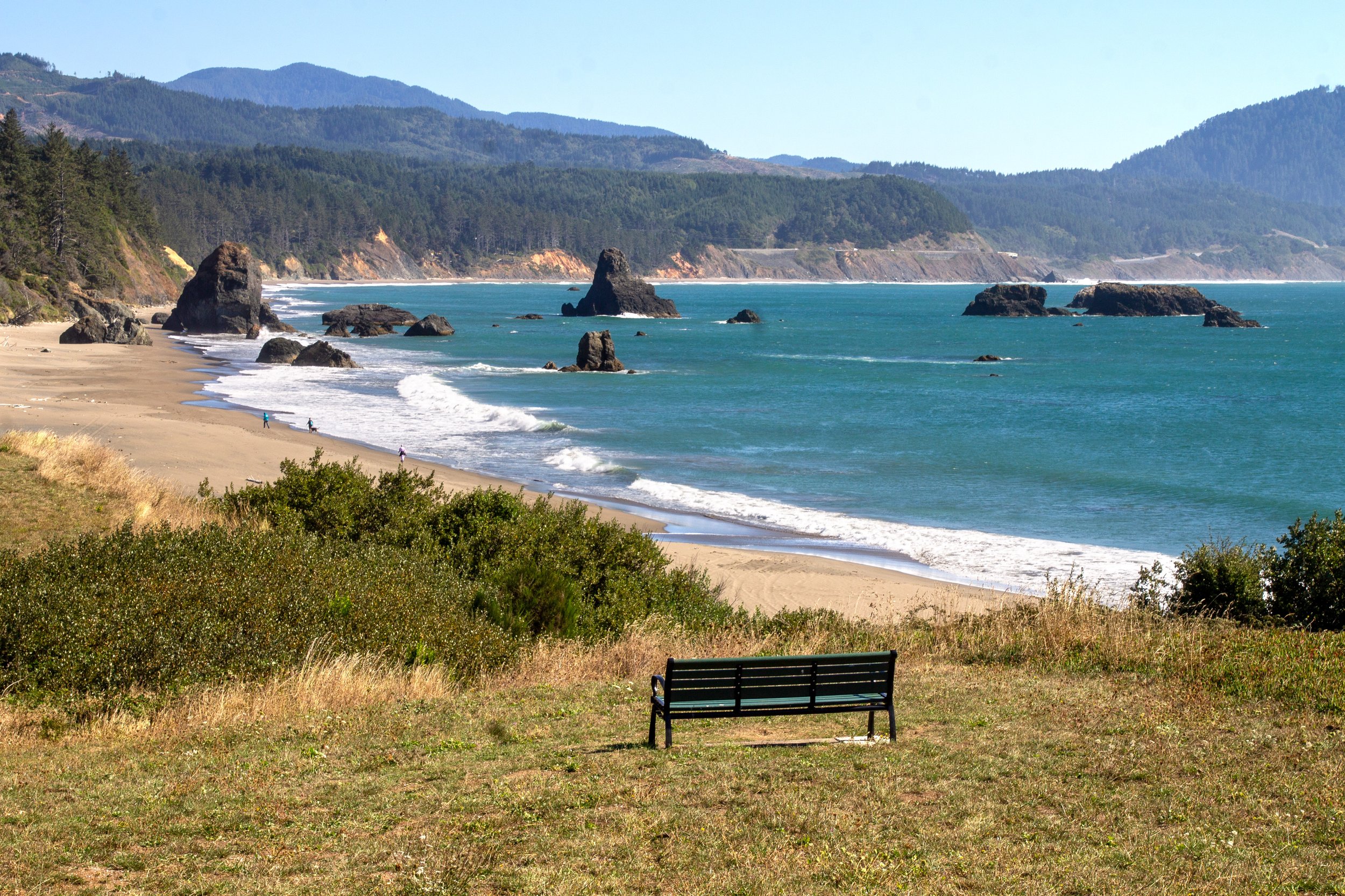 Bench overlooks beach with cool sea stacks in Port Orford