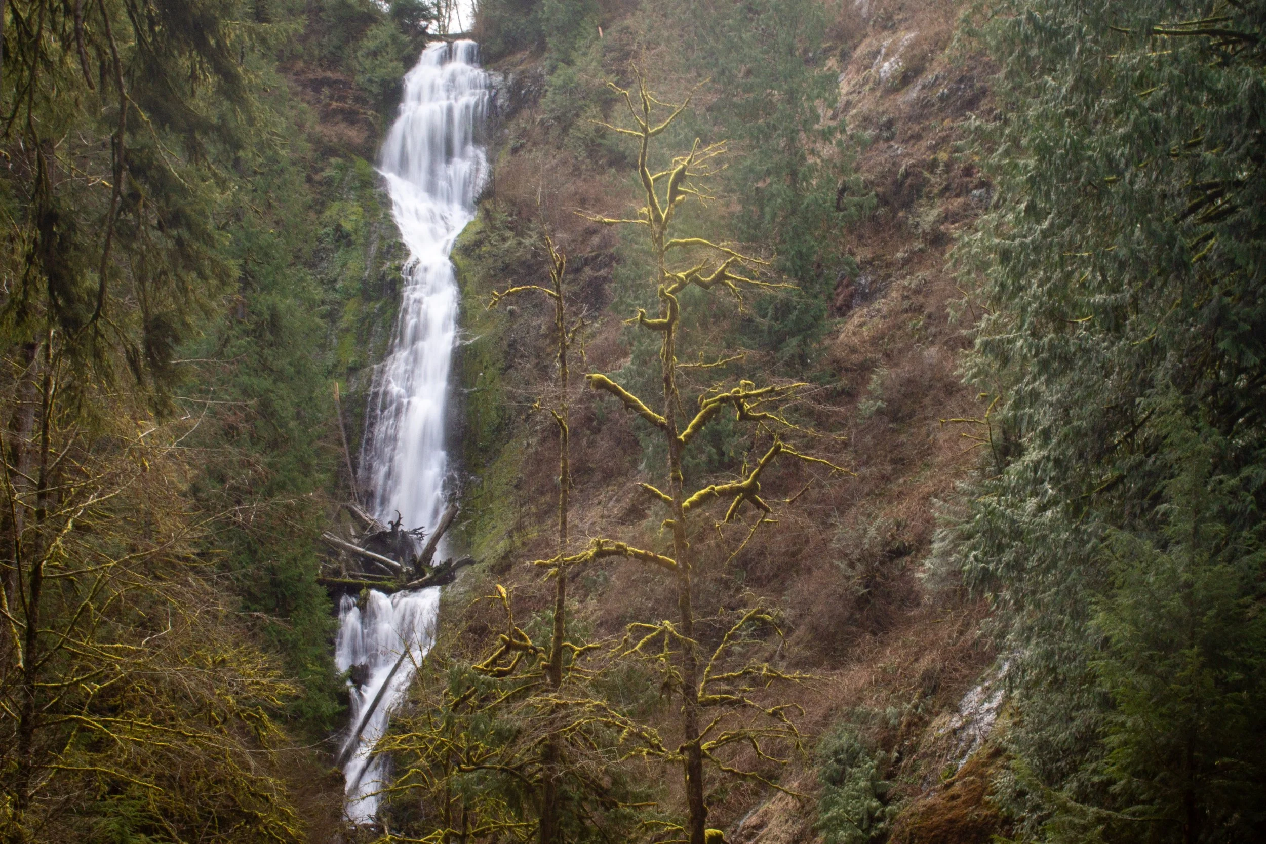 Tall waterfall with many tiers in winter forest