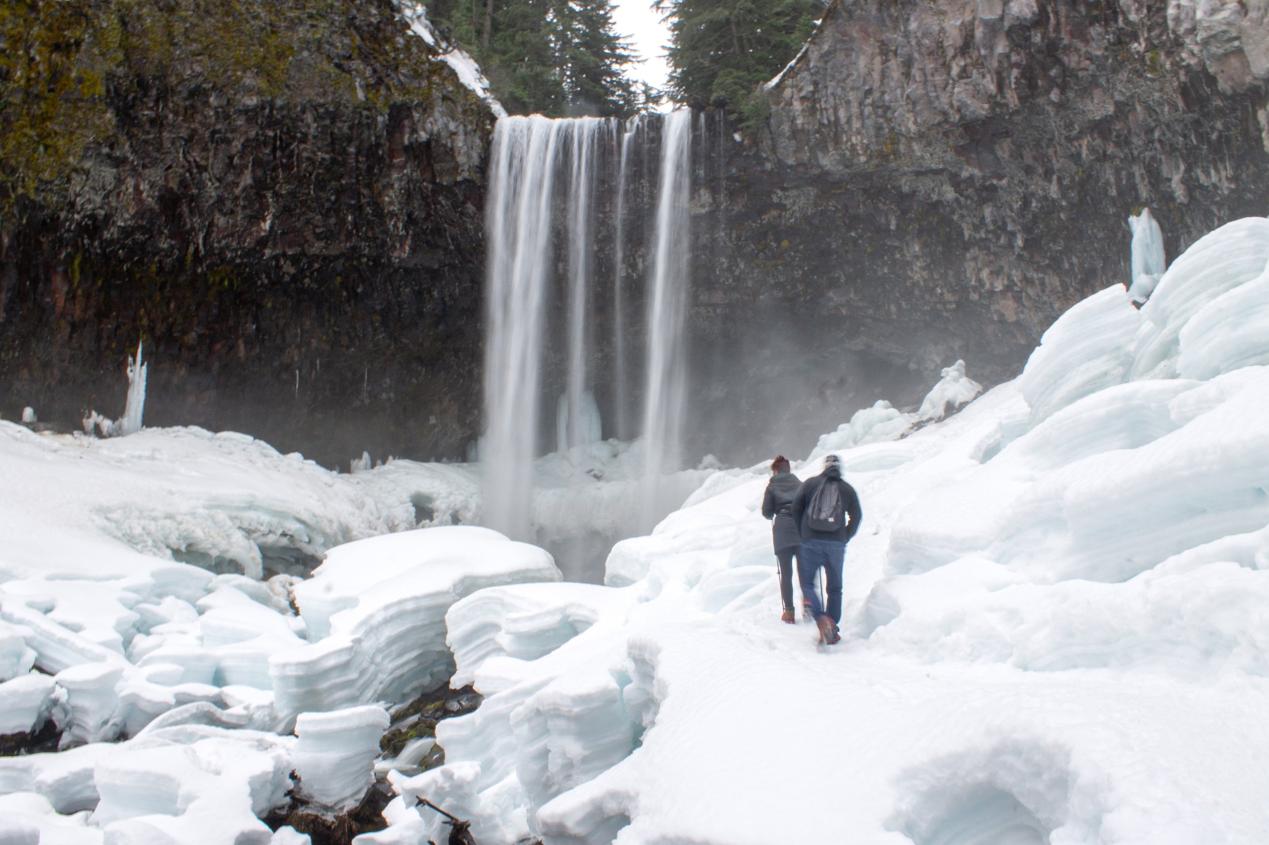 Hikers approach Tamanawas Falls on snowy trail