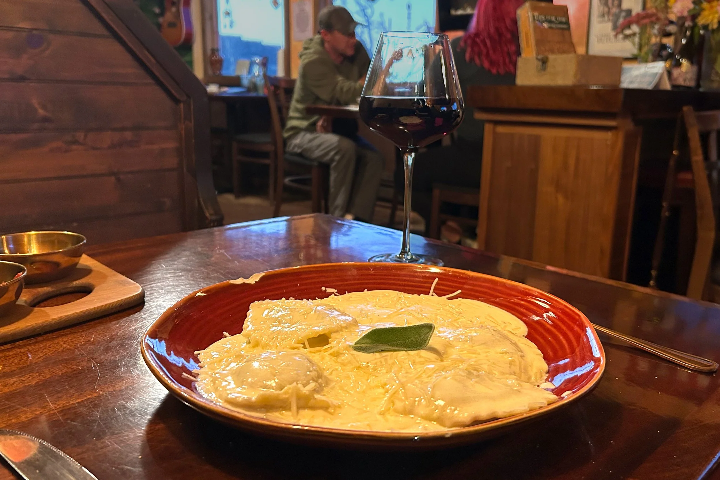 Plate of ravioli and glass of wine in restaurant