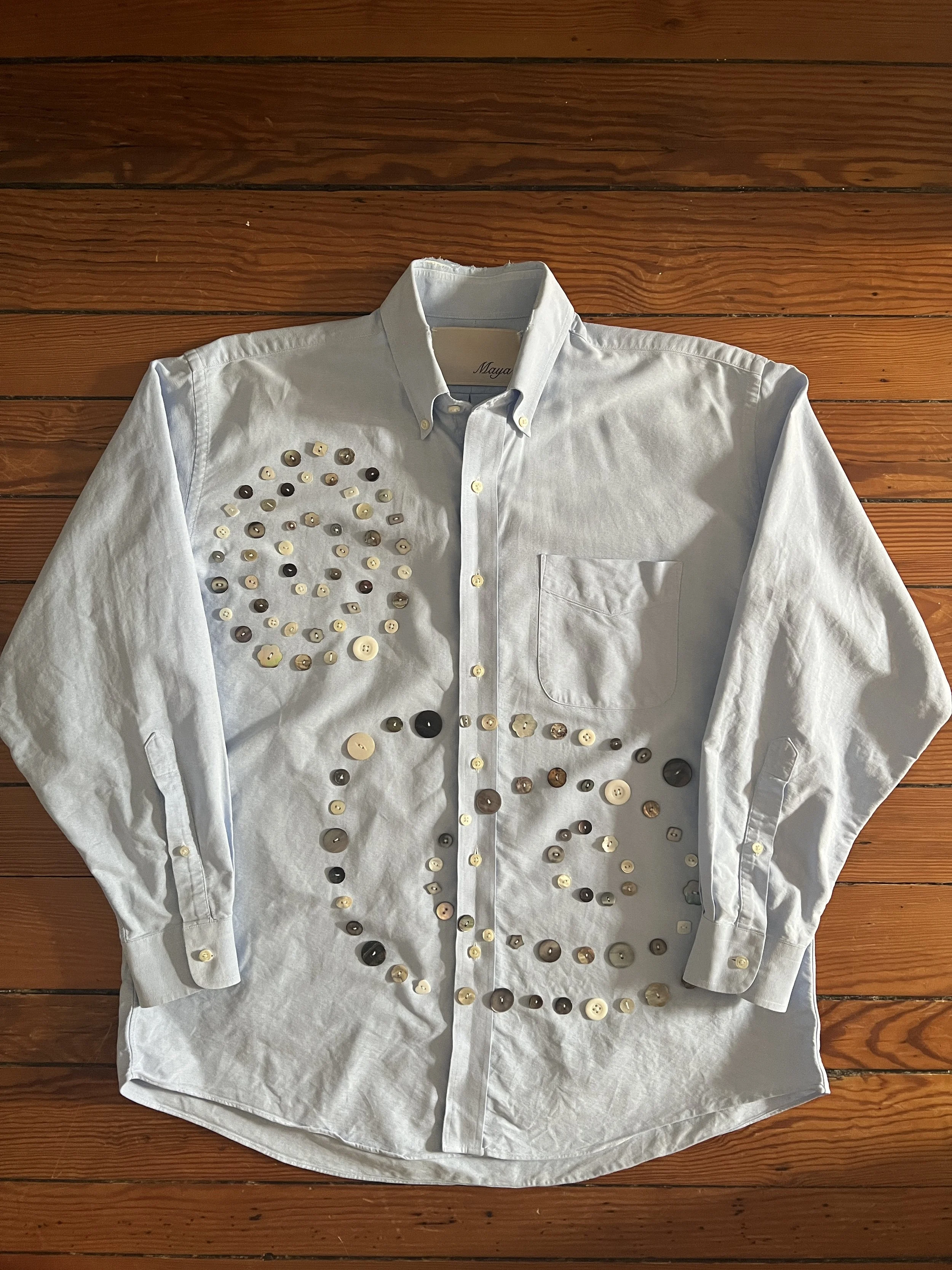 Button Shirt .38 | Size: 16-33 slim fit (men's L) | A thoughtfully sourced second-hand button-up featuring an assortment of hand-sewn buttons. Light blue. To purchase email mayashawcontact@gmail.com with the subject “Button Shirt .38”|$150 + $10 ship