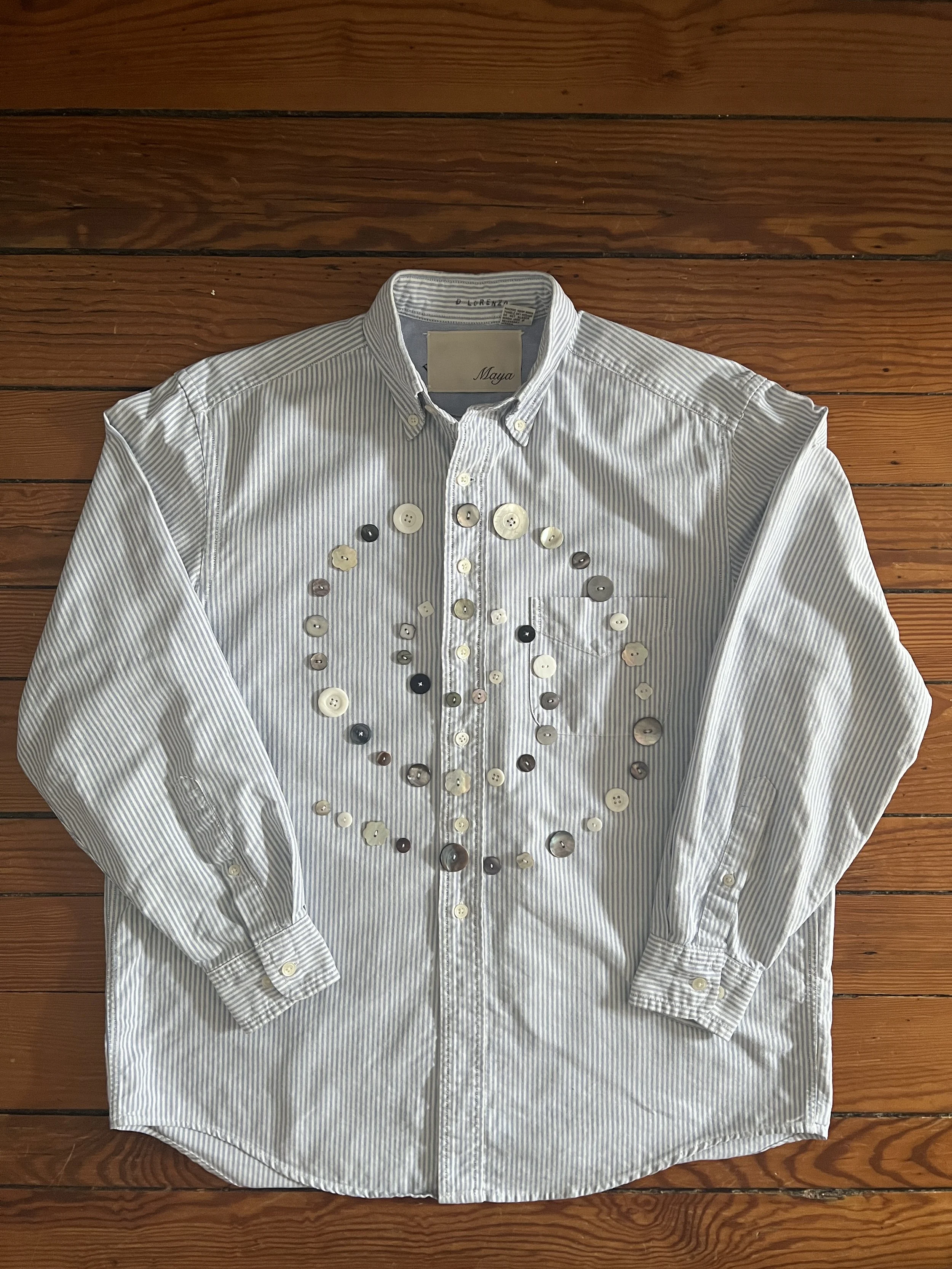 Button Shirt .36 | Size: Men's S | A thoughtfully sourced second-hand button-up featuring an assortment of hand-sewn buttons. Light blue with white stripes. To purchase email mayashawcontact@gmail.com with the subject “Button Shirt .36” | $145 + $10 