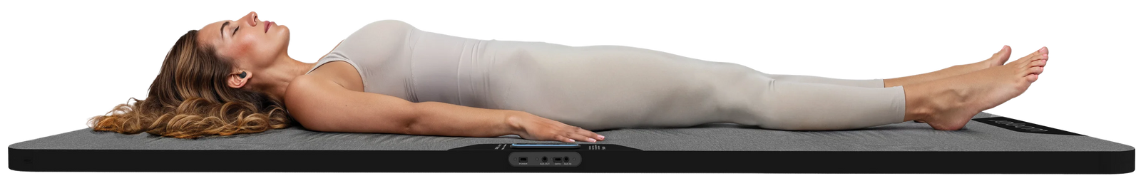A woman lying on the Woojer Haptic Mat