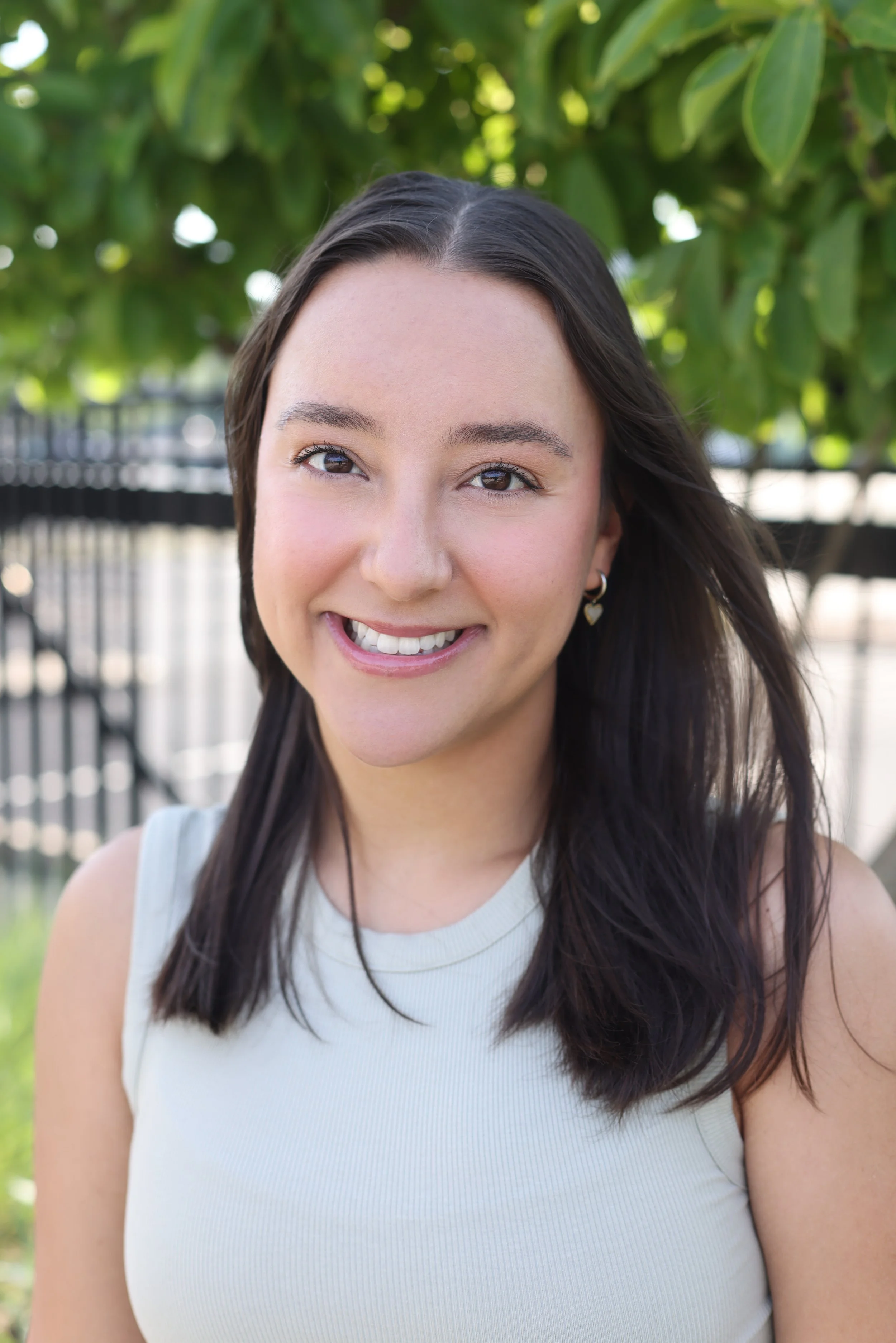 A young woman with brown shoulder length hair and brown eyes smiles big at the camera. Your energetic toddler can grow in social confidence with the support of this therapist and peers in a social skills group. Learn more by reaching out today.