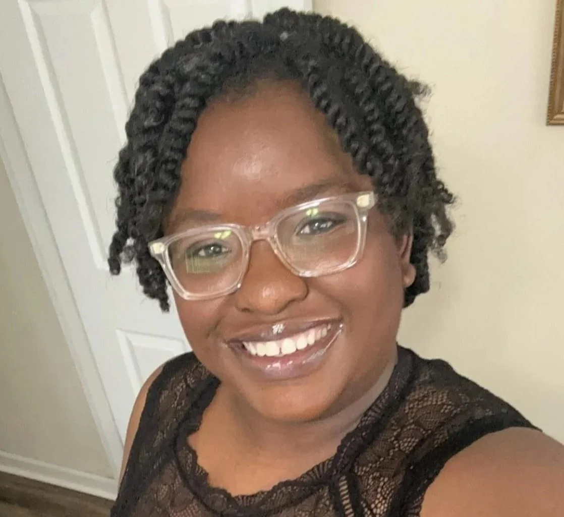 A Black woman with clear glasses smiles at the camera. Trained play therapists can help you understand and respond calmly and confidently to your child's big behaviors.Get started in St. Louis today.