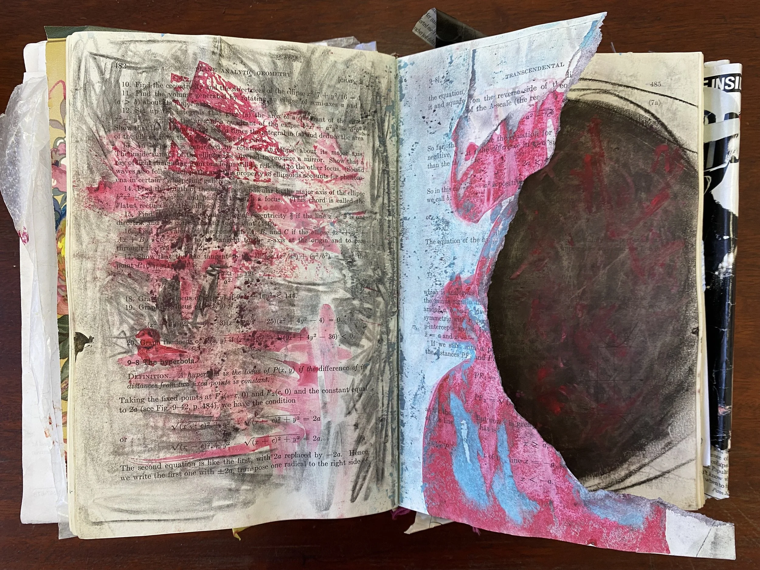 An open book is on a table and the pages of the book have been colored, ripped, and used for art. Art therapy can help kids process trauma without words. Wanna learn more about why play and art therapy is helpful for children? Keep reading.