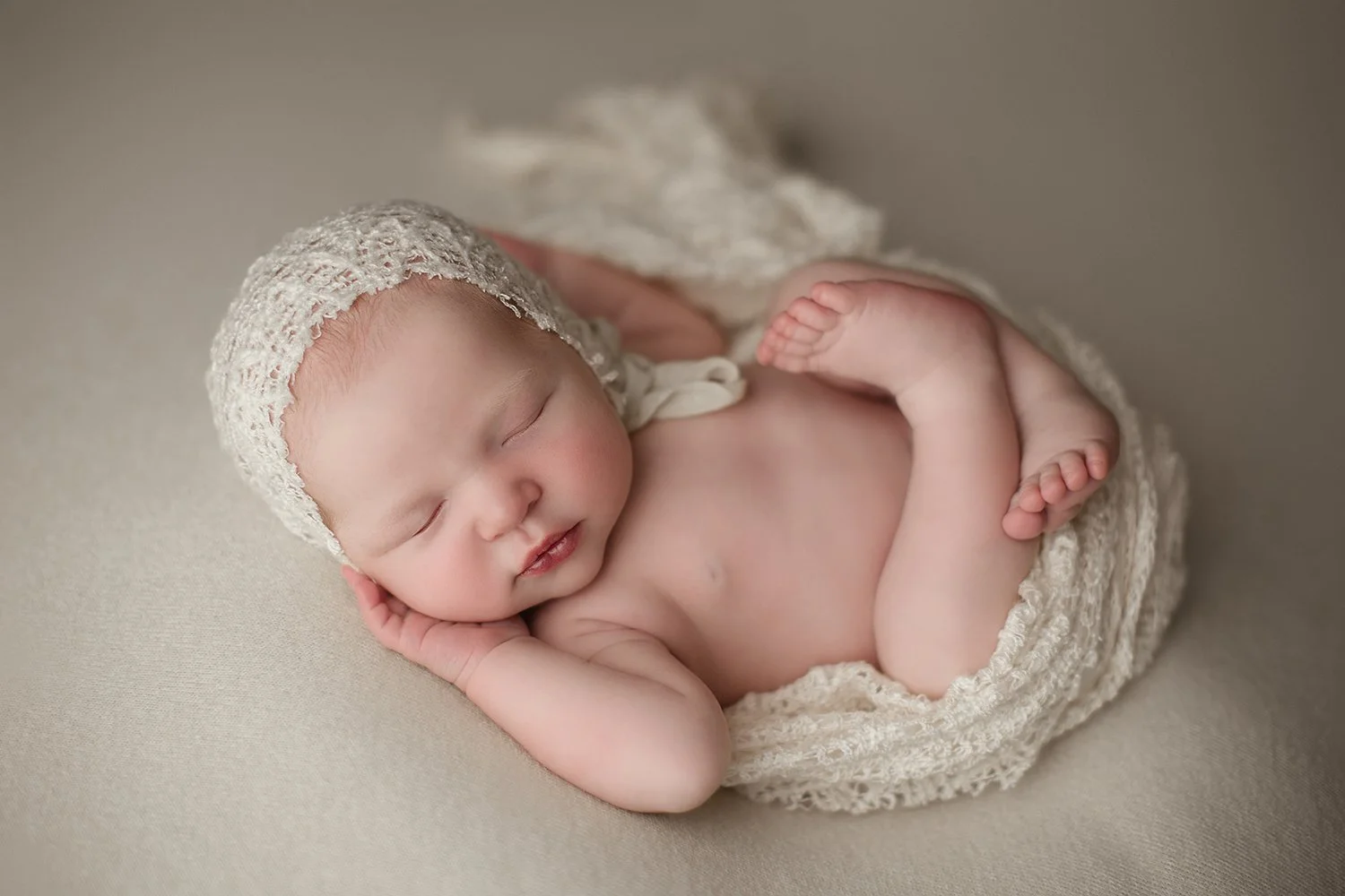 Houston, Texas Maternity Photographer Newborn baby sleeping photos, baby is wrapped in a cream blanket and wearing a bonnet, baby is laying on its back and sleeping,  baby is calm and comfortable, Houston, Texas newborn photographer, travel newborn p