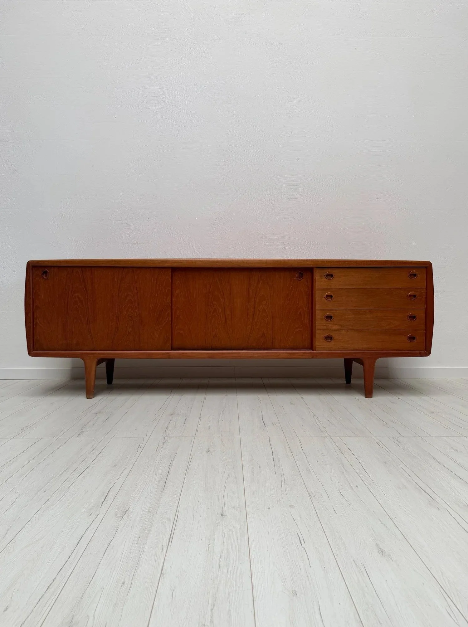Large Teak Sideboard by H.P. Hansen, 1960s

It is the quiet details that define great Danish cabinetmaking &ndash; here, a raised edge running along the front of the top and a softly sculpted frame.

Two sliding doors, four drawers and integrated han