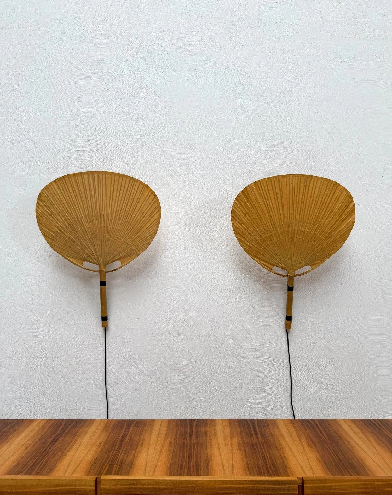 Pair of Uchiwa III Wall Lamps by Ingo Maurer for M-Design, 1973

Ingo Maurer took his inspiration from traditional Japanese uchiwa fans &ndash; and turned bamboo and paper into one of the most poetic lights of the 1970s.

A matching pair giving a war