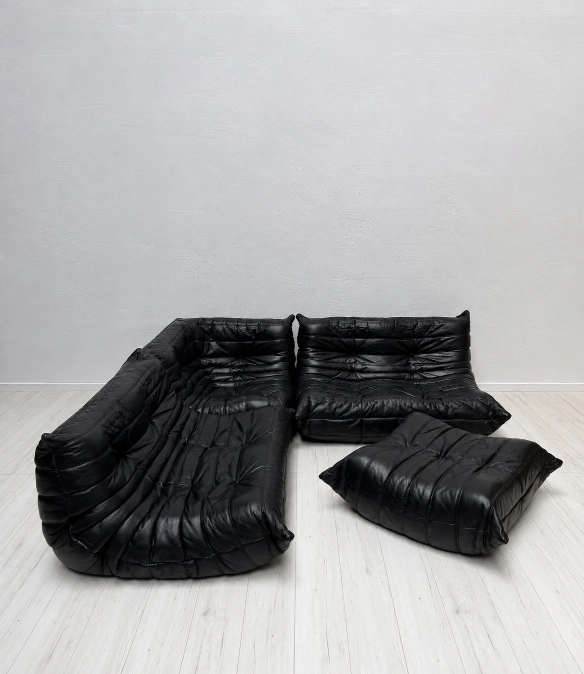 Togo Lounge Set by Michel Ducaroy for Ligne Roset, 1990s

When Michel Ducaroy presented the Togo in 1973, he described it as a tube of toothpaste folded over at both ends. No frame, no legs &ndash; just foam and a pleated cover. Fifty years later, it