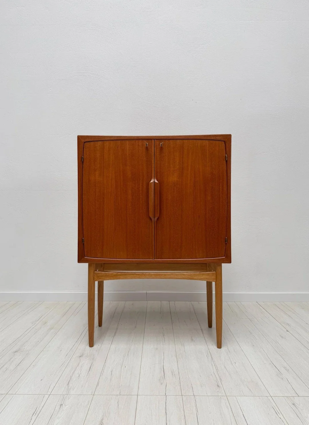 'Bacchus' Bar Cabinet by Torbj&oslash;rn Afdal for Mellemstrand, 1950s

Sculptural handles, clean lines and a cleverly fitted interior for bottles, glasses and bar tools &ndash; Norwegian modernism at its most elegant. Professionally restored by a co
