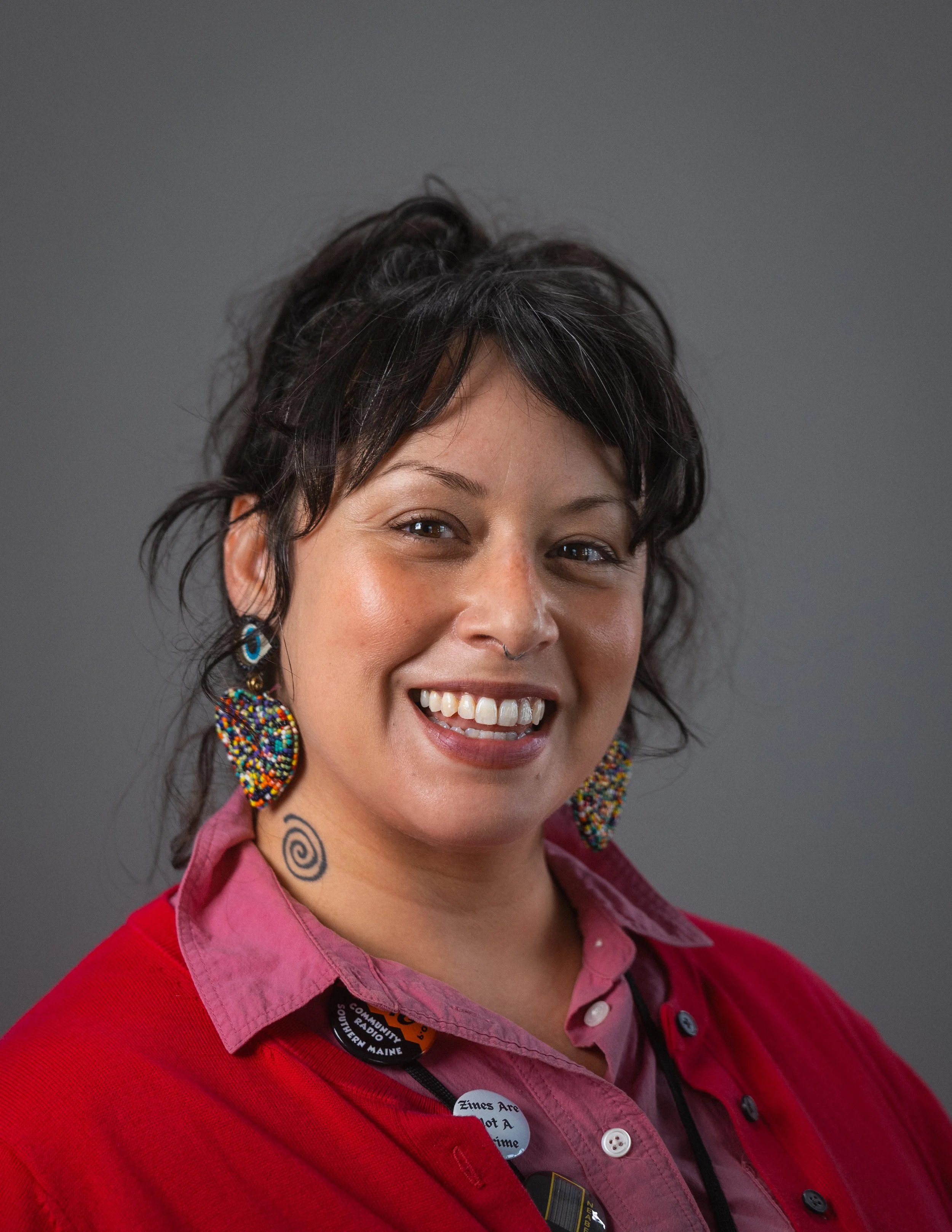Photograph of Julia Arredondo in front of a gray background. Julia smiles at the camera. Photo by Zach Boyce.