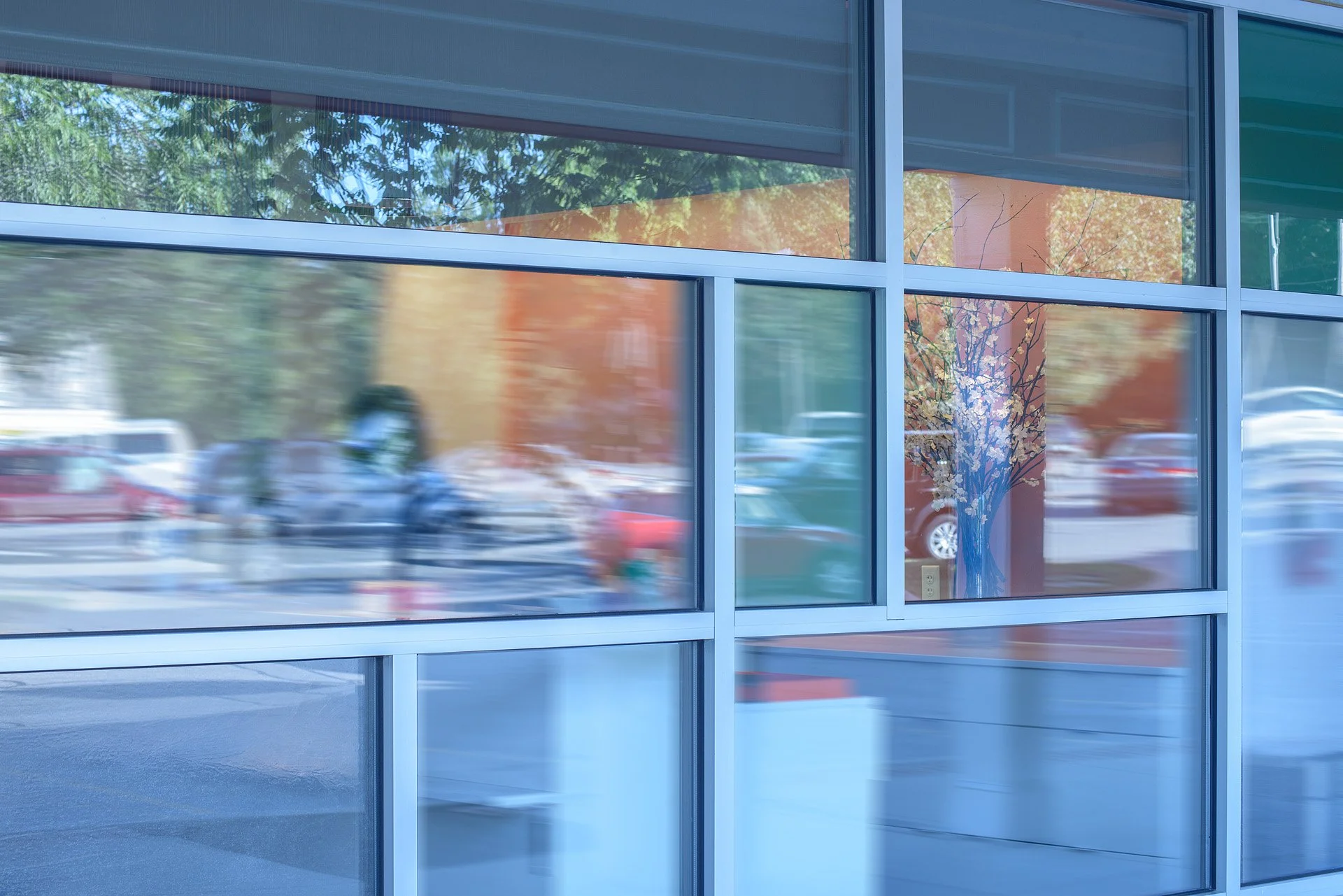 Reflections in the mid-century modern inspired mosaic pattern of the exterior window panes of bijin salon & spa in The Shops of Prairie Village.