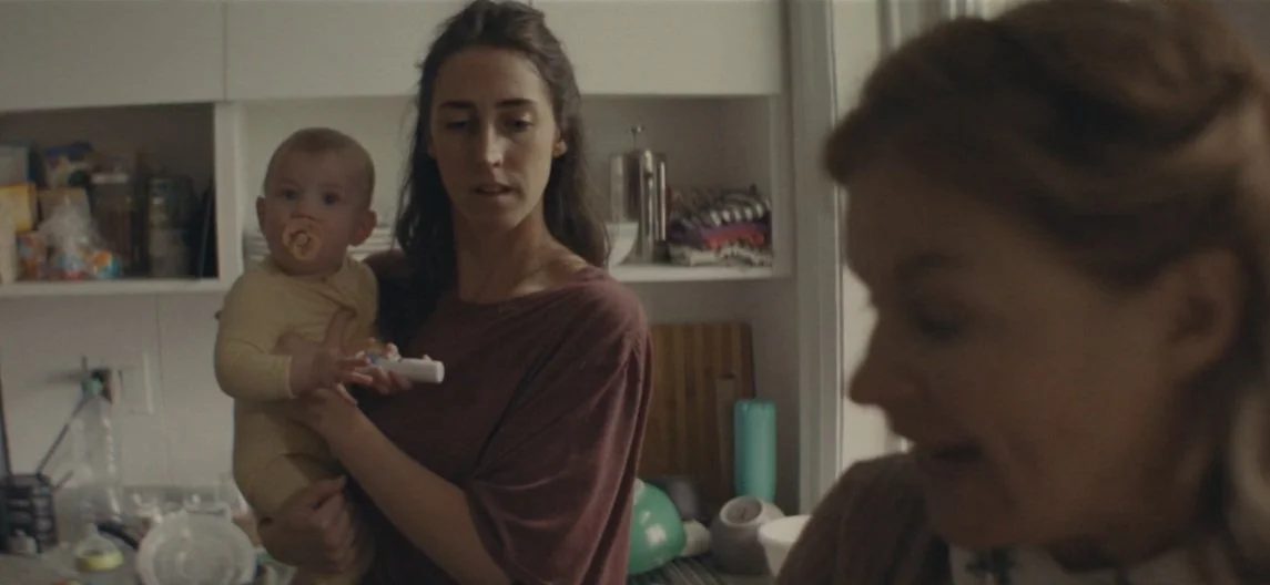 A suspicious neighbour presses her way into the kitchen of a private new mother.