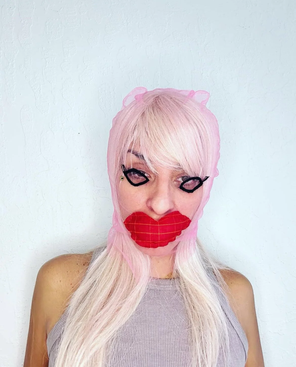 Pink tulle mask with embroidered eyeliner, lashes, beauty mark, and puffy red plaid lips
