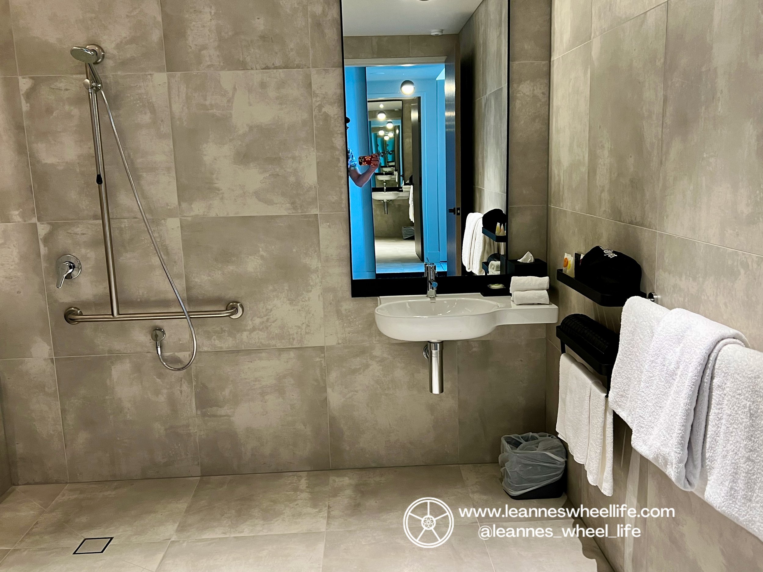  Hyatt Place Melbourne Caribbean Park fully wall and floor tiled smudged grey-white tile colour. Roll under sink with towel rails and open plan shower to left 