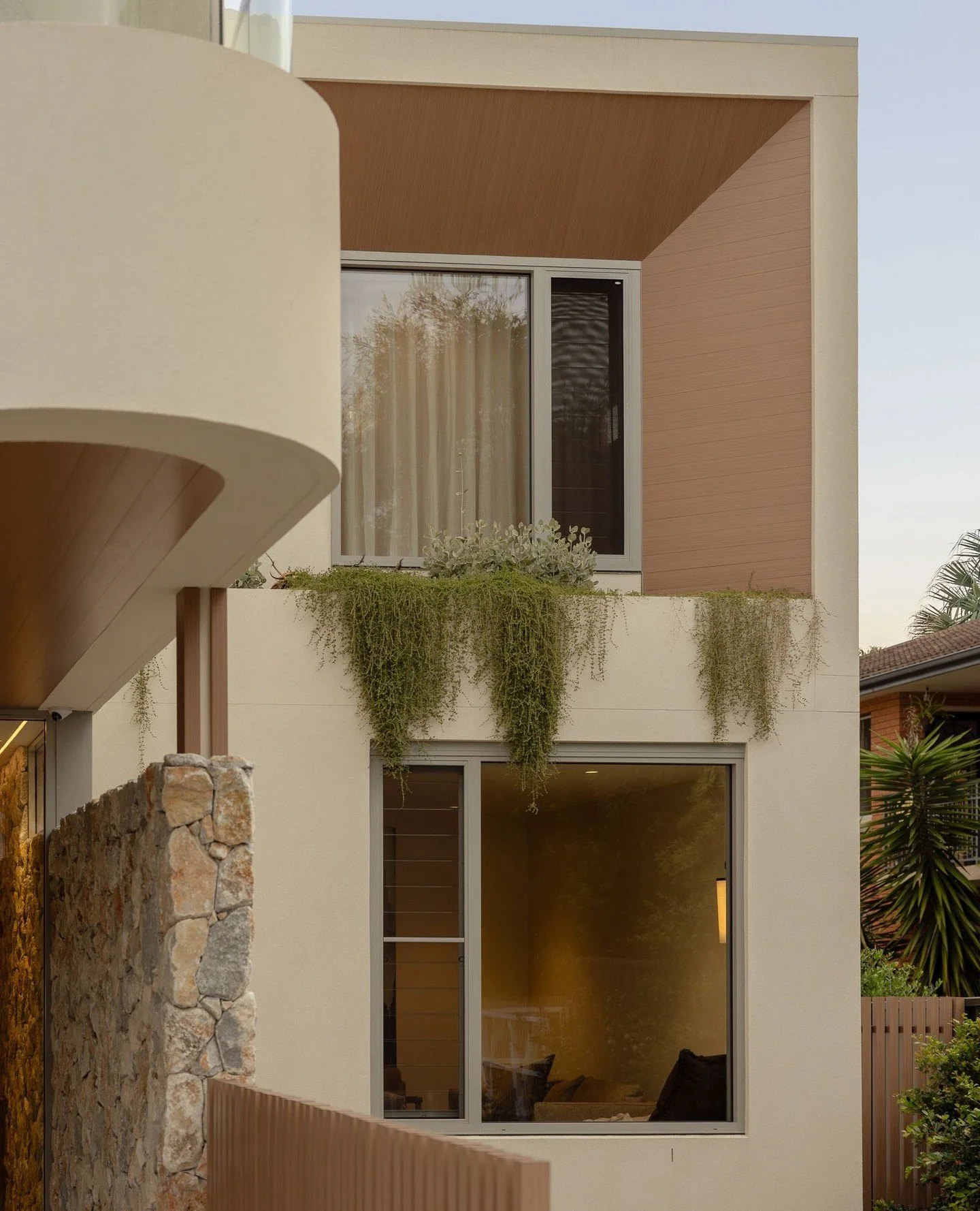 Architecture and landscape combine. Cascading greenery softens the clean lines of the rendered front facade, creating a stunning first impression. Integrated planter boxes were carefully designed and constructed to support healthy, thriving plants.⁠
