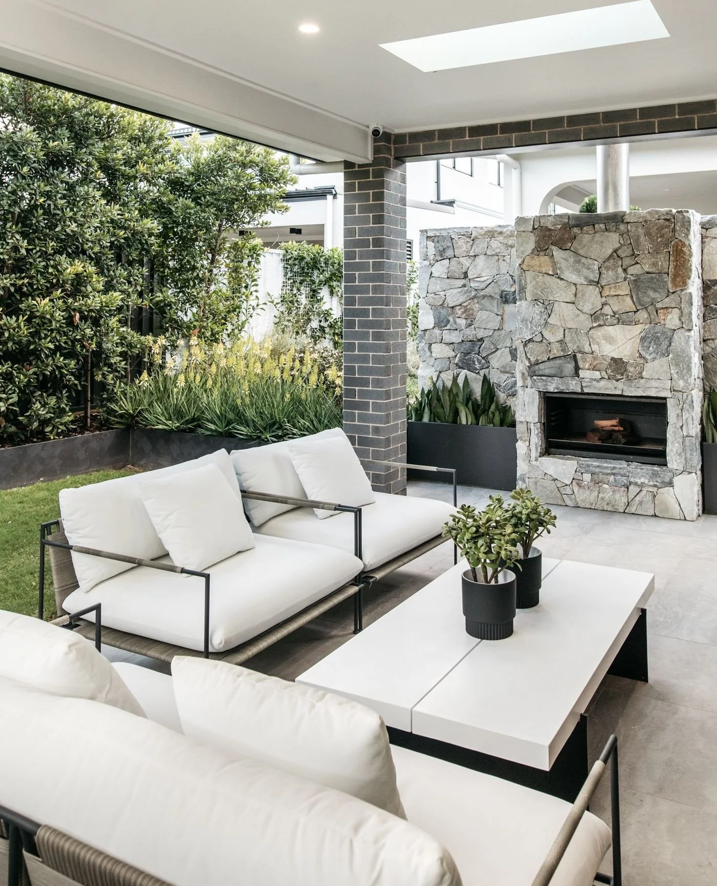 Blurring the line between indoors and out. Natural stone, soft furnishings and plant styling work together to create an inviting outdoor living area that naturally draws you out from the interior space.