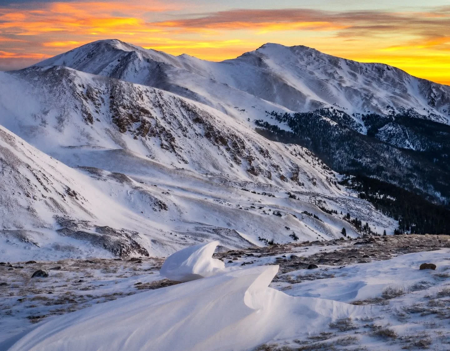 Up here winter writes its own patterns, wind shaping the snow through the night, leaving small sculptures scattered across the ridge. By sunrise the mountains finally show them off.

#RockyMountains #ColoradoPhotography #MountainSunrise #WinterMounta