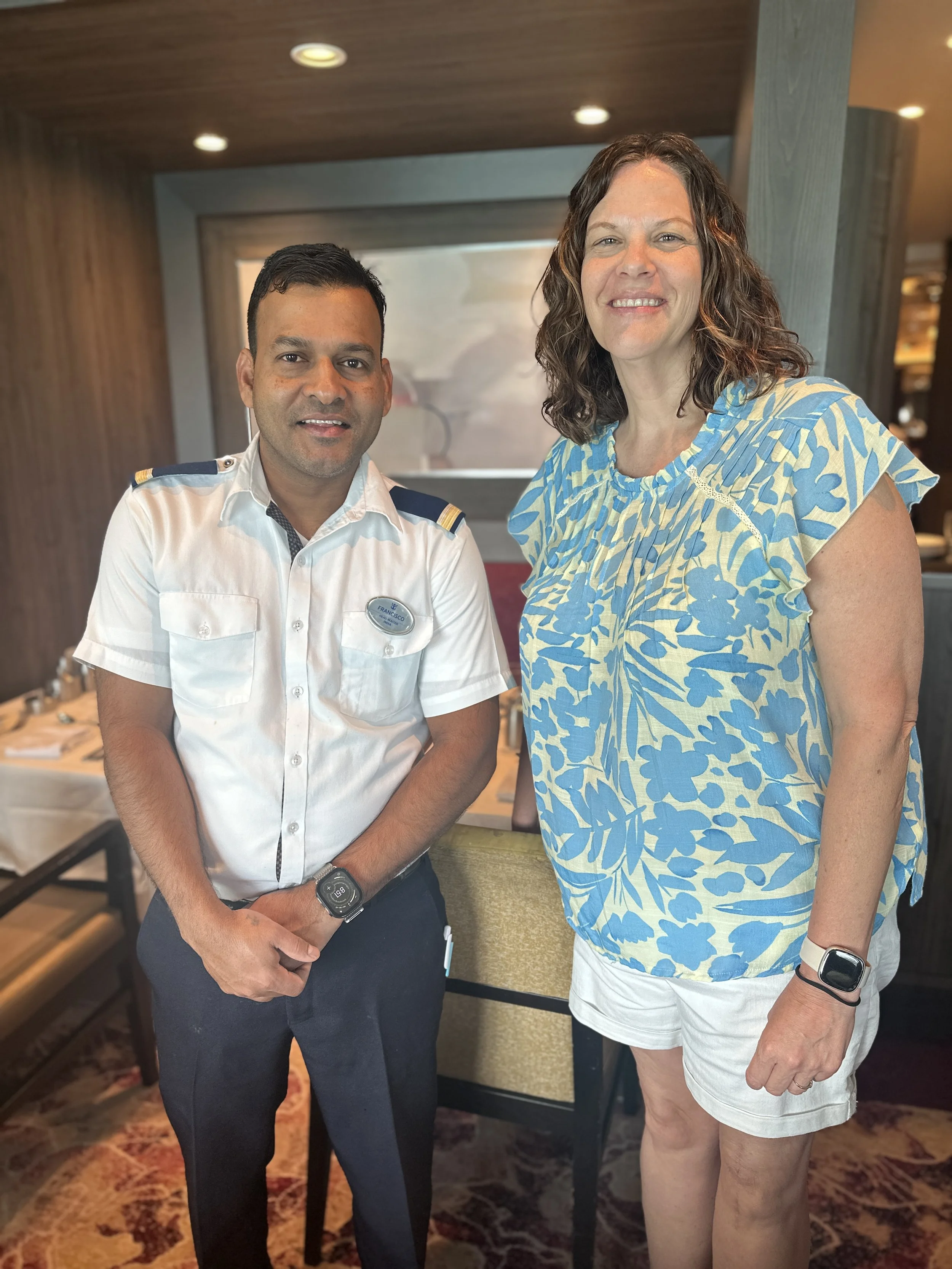 Woman standing next to a man in a waiter uniform