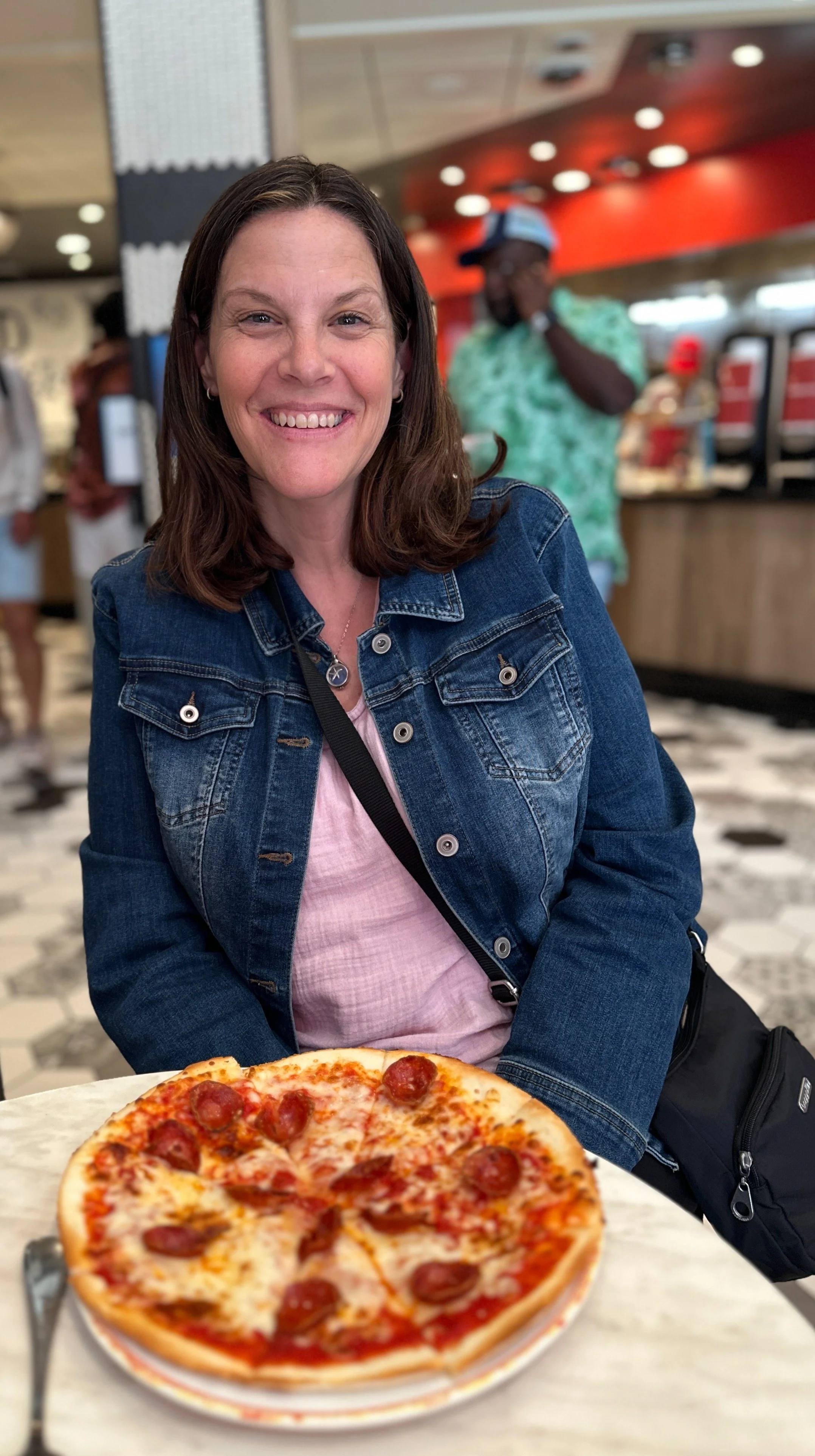 Woman behind a table with gluten-free pizza