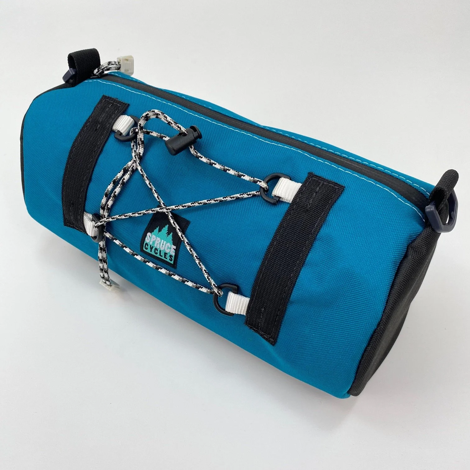 Blue and black cycling bag with attached bungee cords and a 'Spruce Cycles' logo