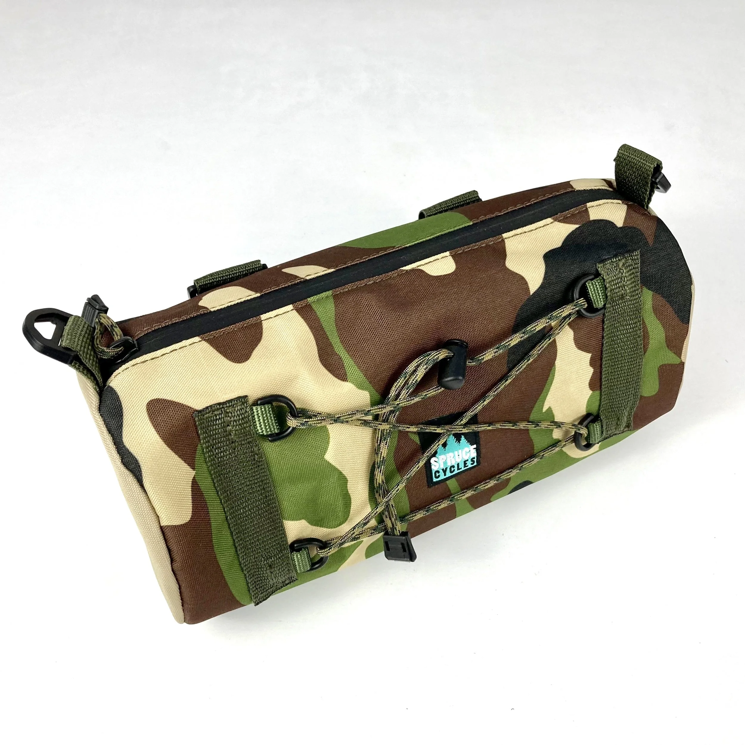 Camouflage-patterned saddle bag with a bungee cord and a "Spruce Cycles" logo.