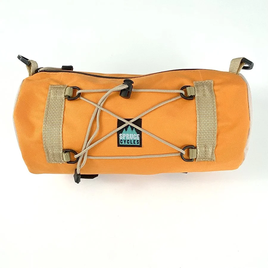 Orange and beige Spruce Cycles bicycle saddlebag with bungee cords for securing items.