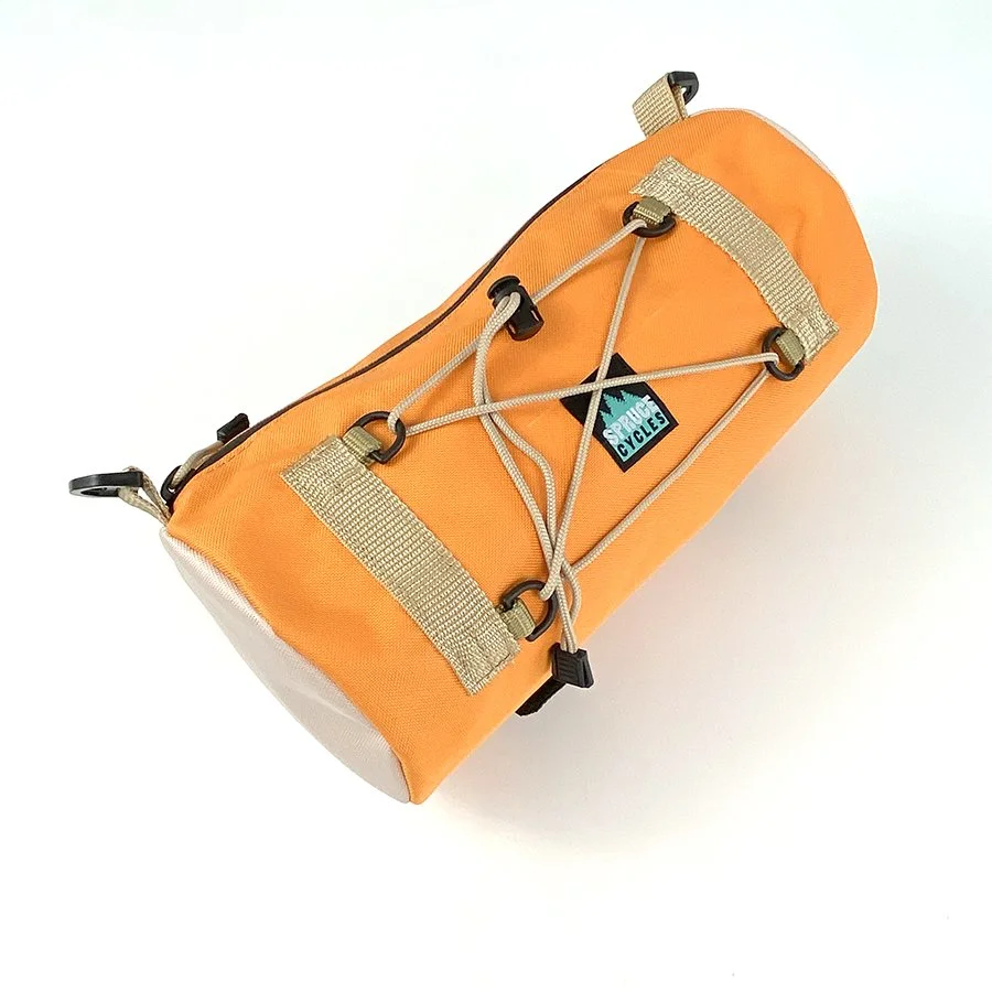 Orange cylindrical bag with straps and bungee cord for securing gear, labeled 'Special Cycles,' on a white background.