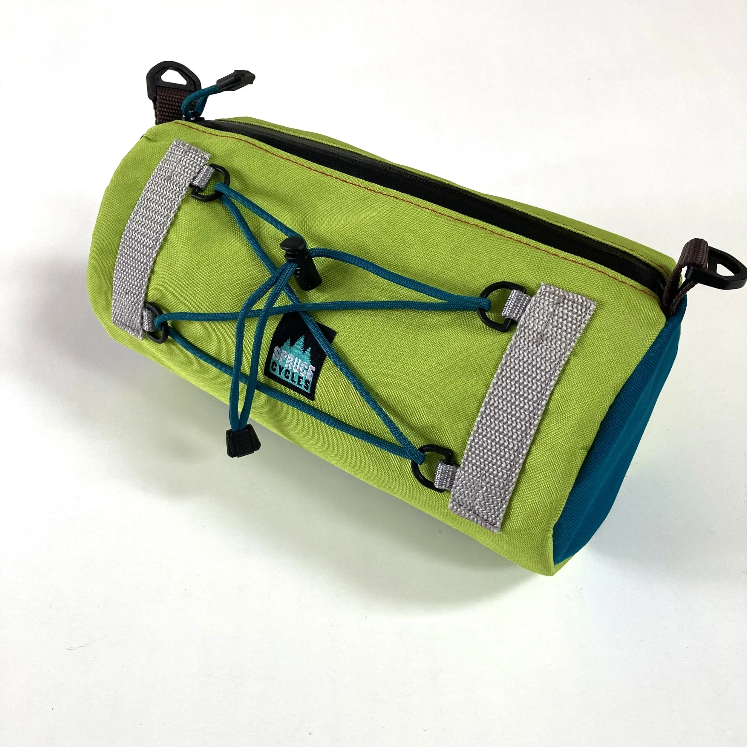 A lime green and blue cycle bag with reflective strips and a bungee cord on the front, on a white surface.