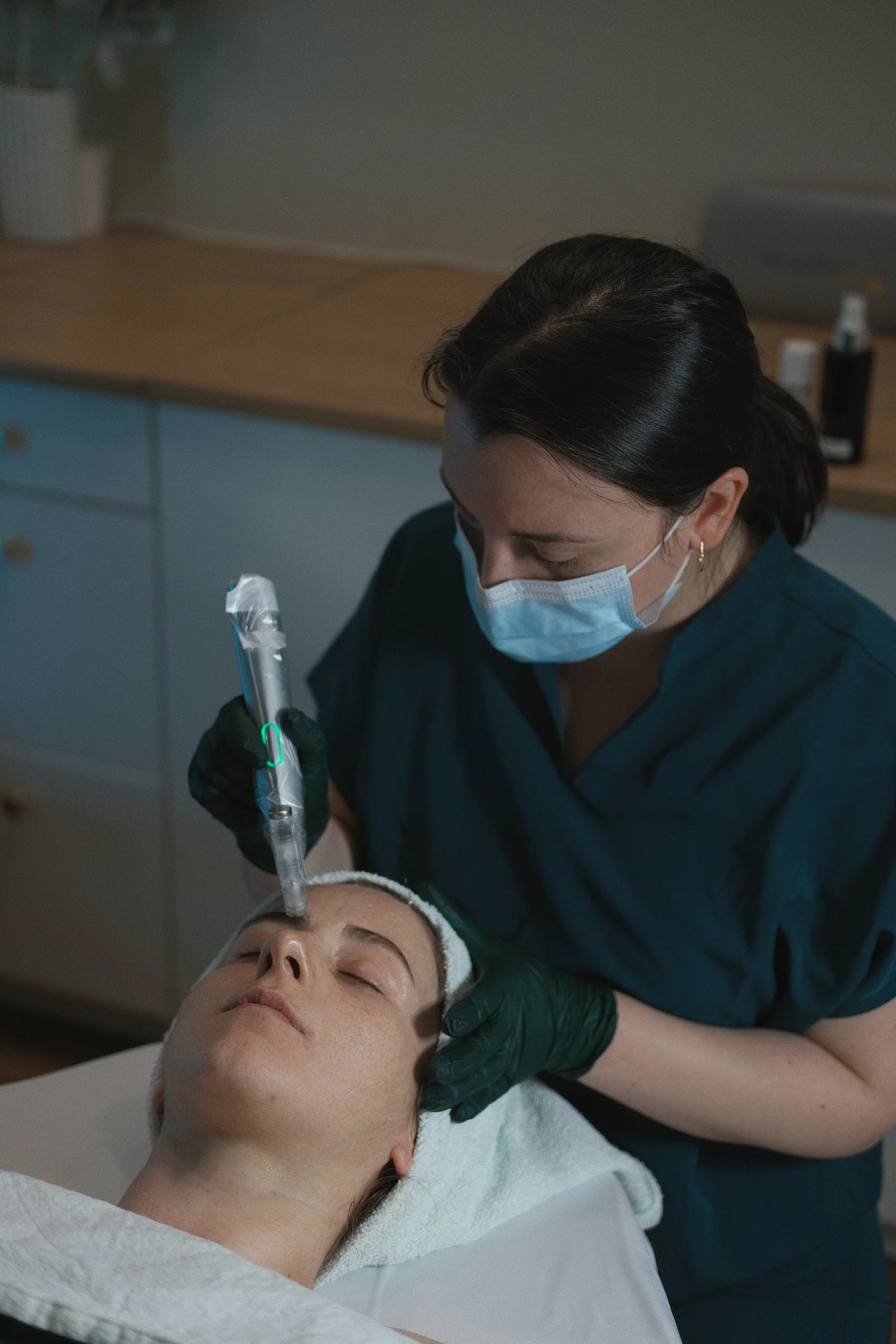 A clinician does microneedling on the face of a young woman in vancouver