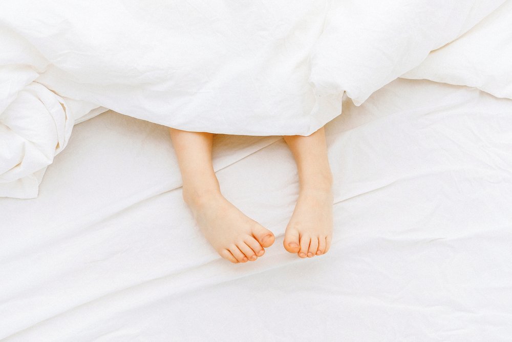 feet sticking out from under sheets