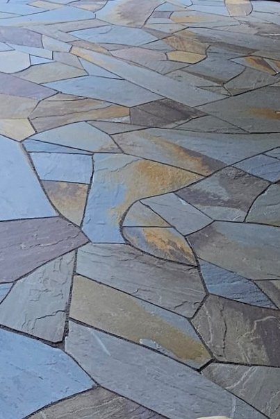 Close-up of a stone patio with irregularly shaped, multi-colored stones.