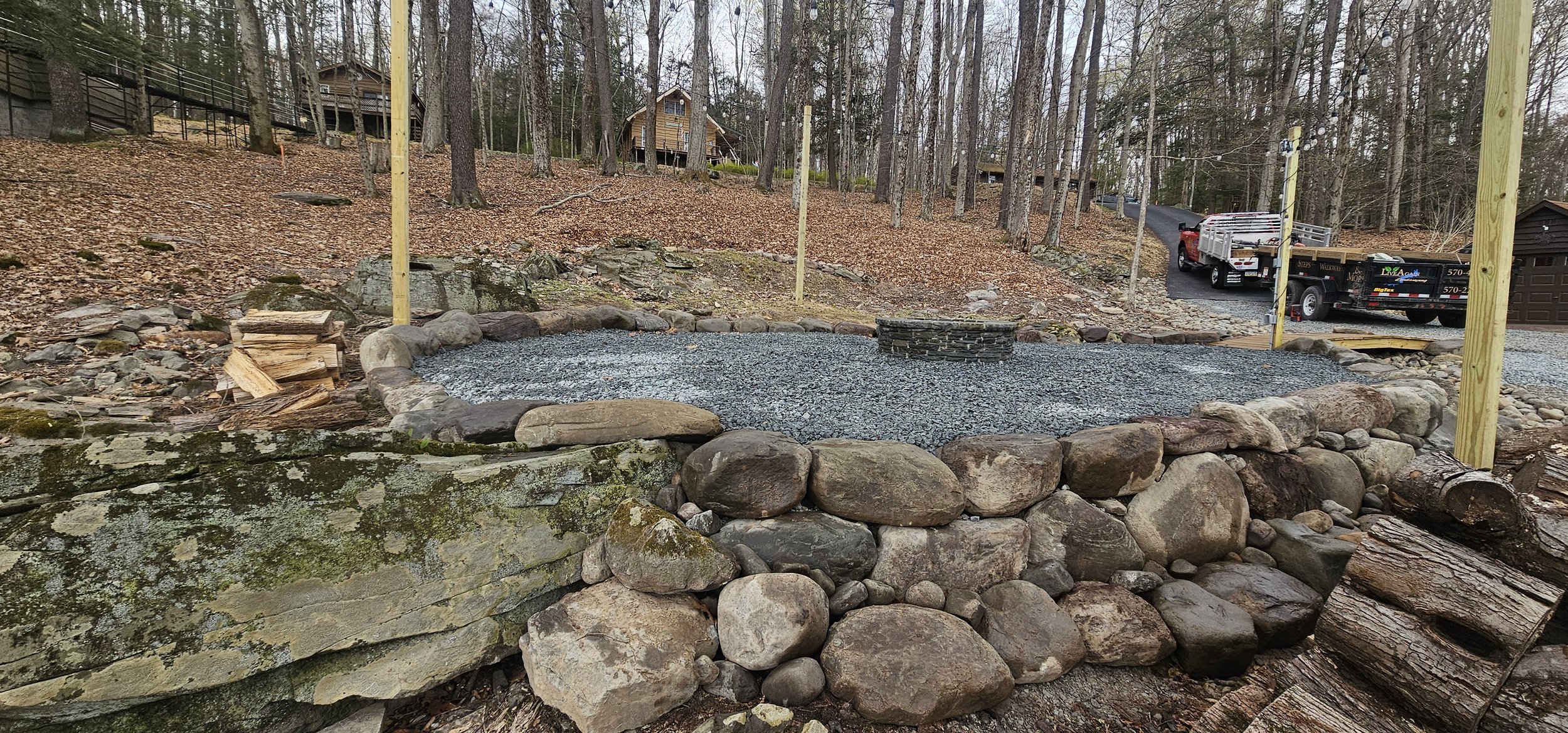 Small boulder embankment with gravel patio and fire pit