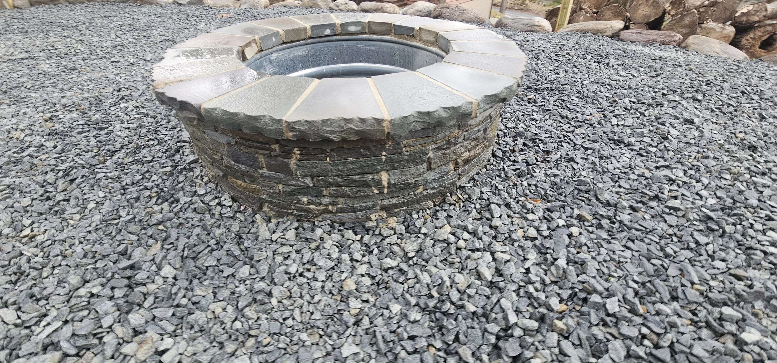 Stone patio with fire pit featuring stacked stone design
