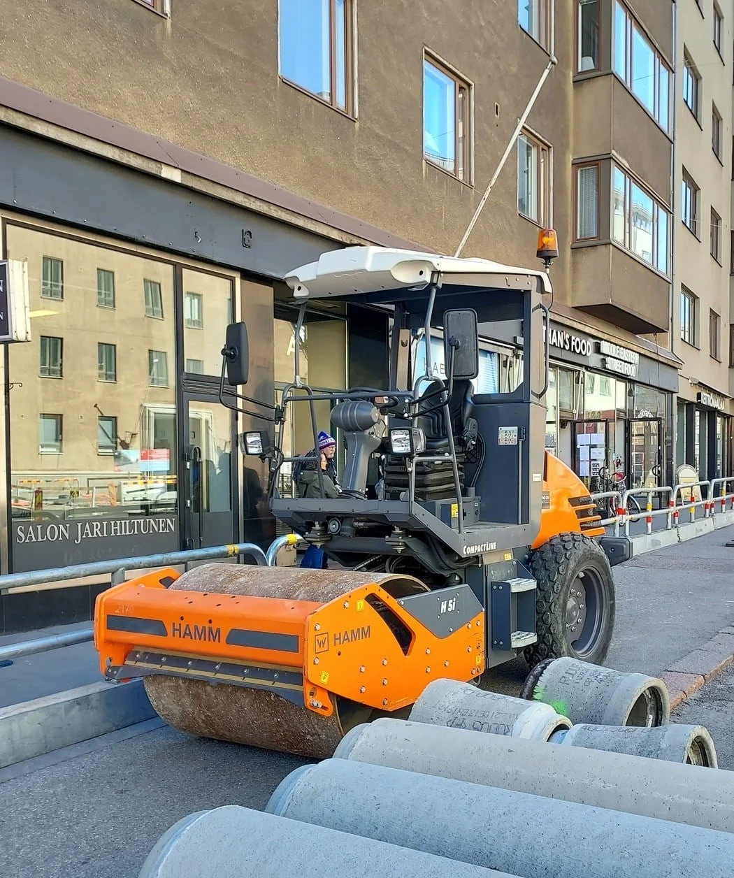 Jyrä Helsingin kadulla, taustalla rakennuksia ja ihmisiä.