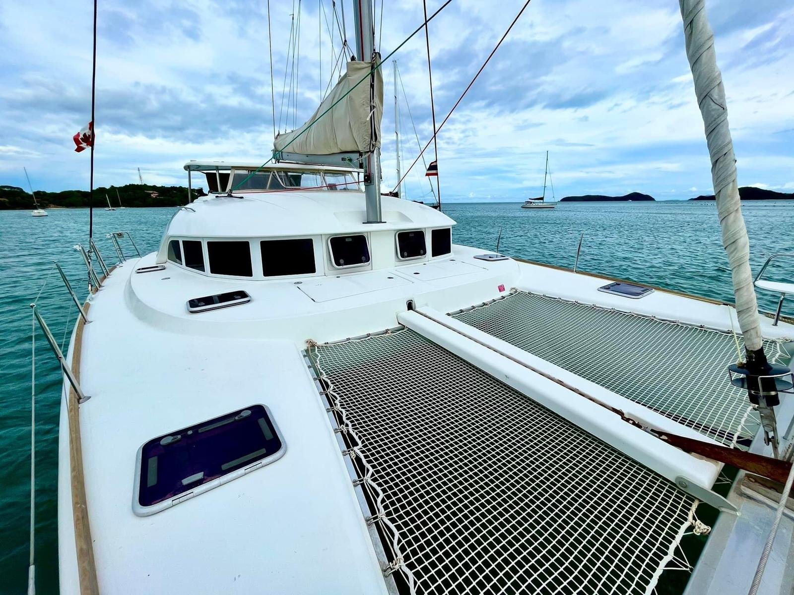 Guests relaxing on the bow trampoline of Logan's Run catamaran near Coral Island.jpg