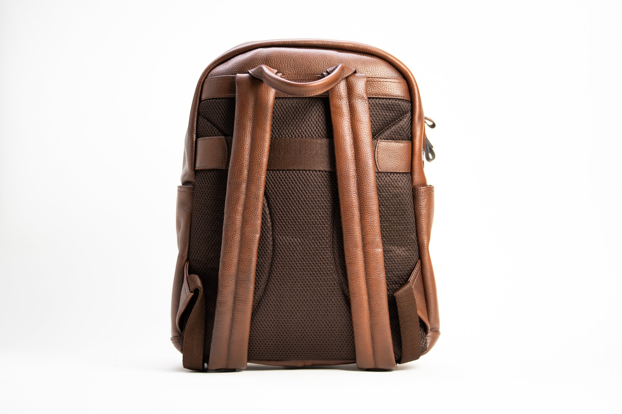A brown backpack with padded shoulder straps and multiple compartments, set against a plain white background.