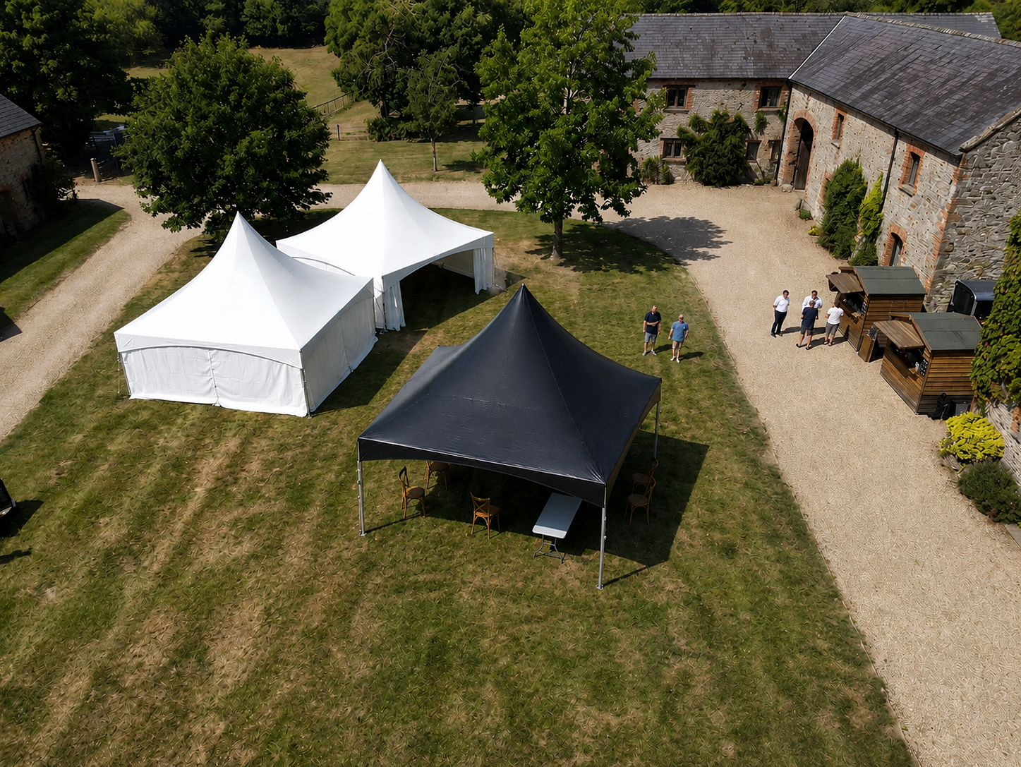 black tent next to traditional white tent 20x20 on grass
