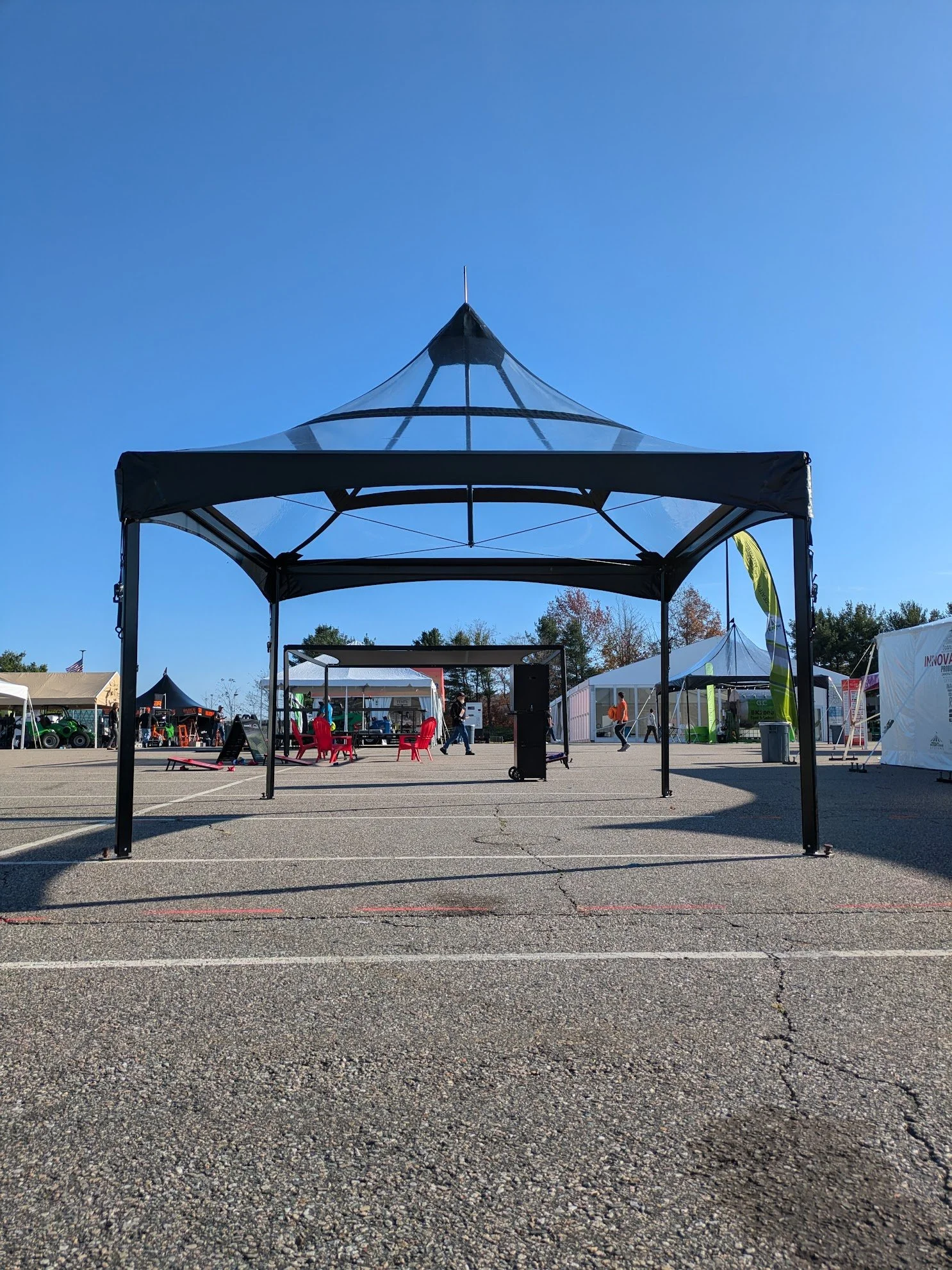 15x15 black high peak set up on a parking lot with clear tent top