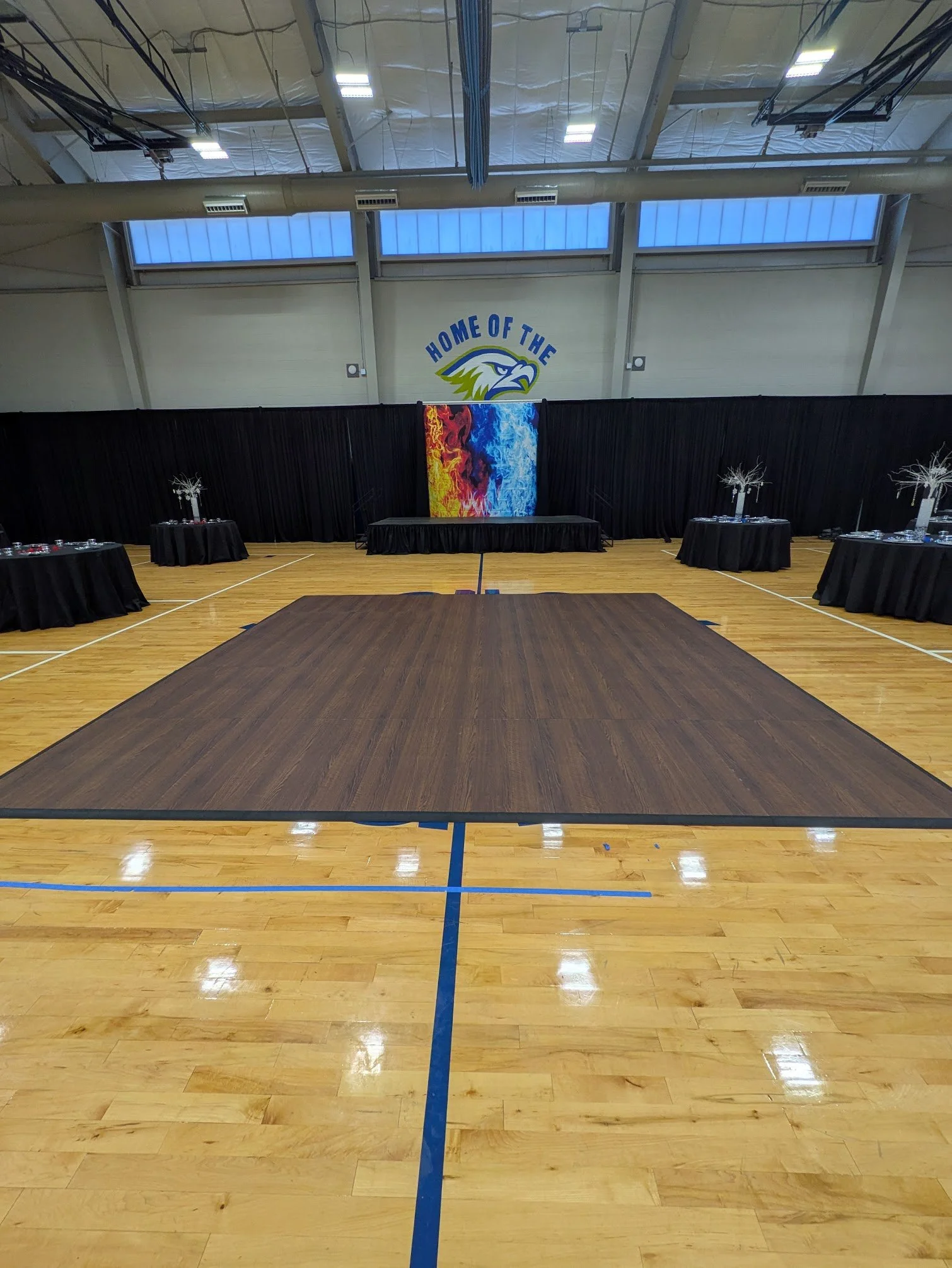dark maple dance floor set up in a gym for a company holiday party in atlanta
