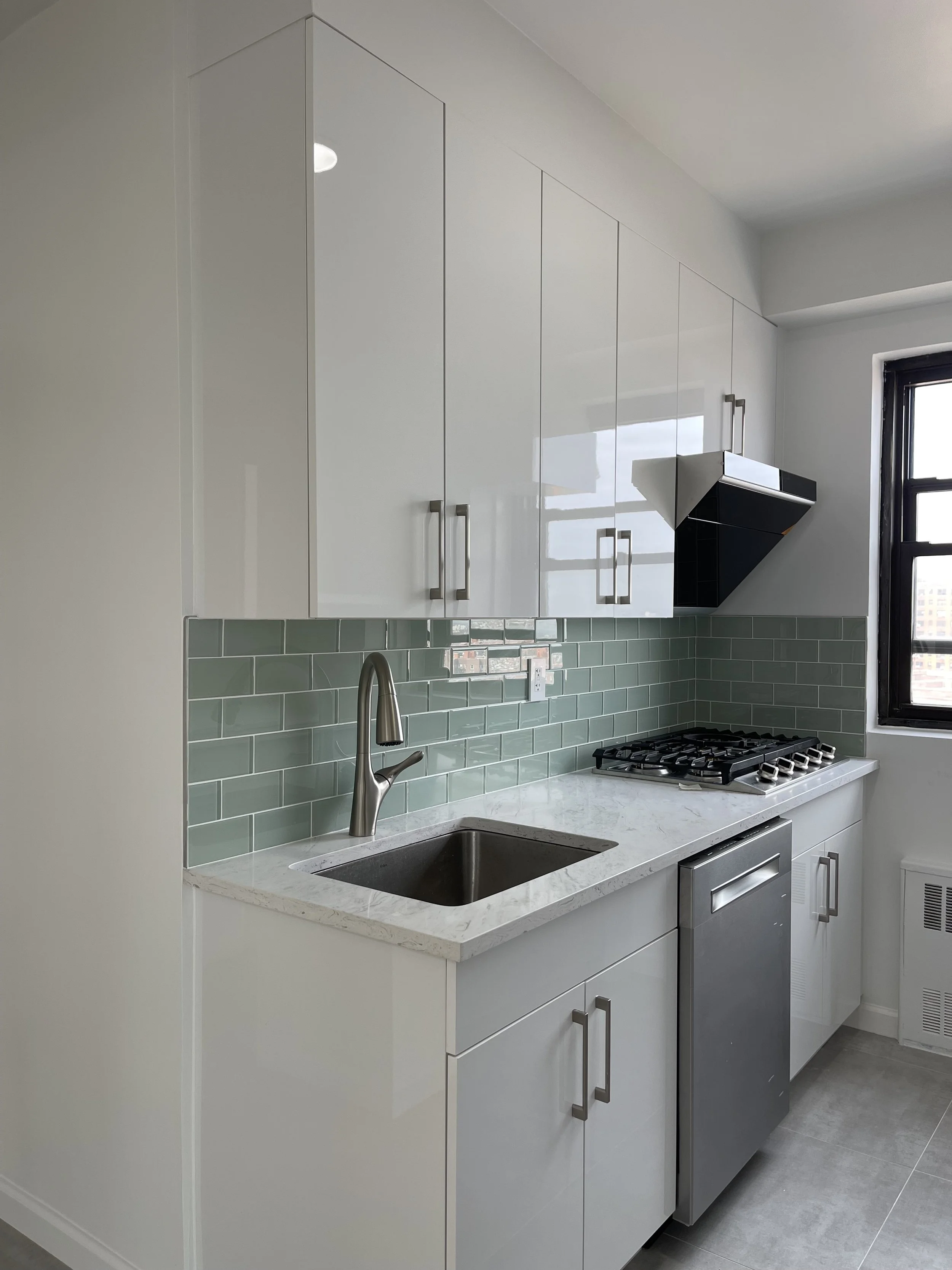Glossy White Apartment Kitchen with Custom Vent
