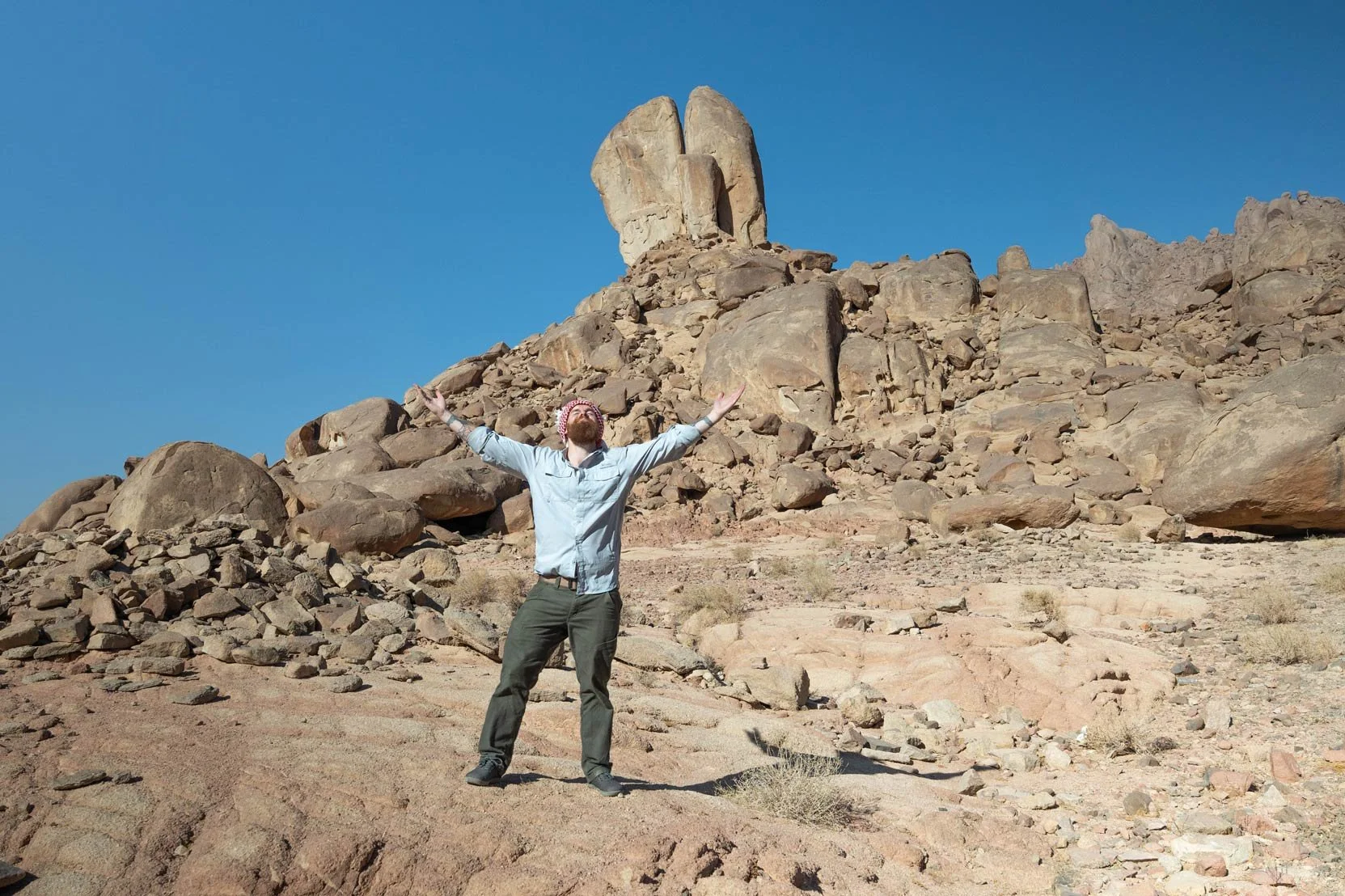 Will Andrew Smith of Snazzy Travel standing in front of the famous split rock in Saudi Arabian wilderness.
