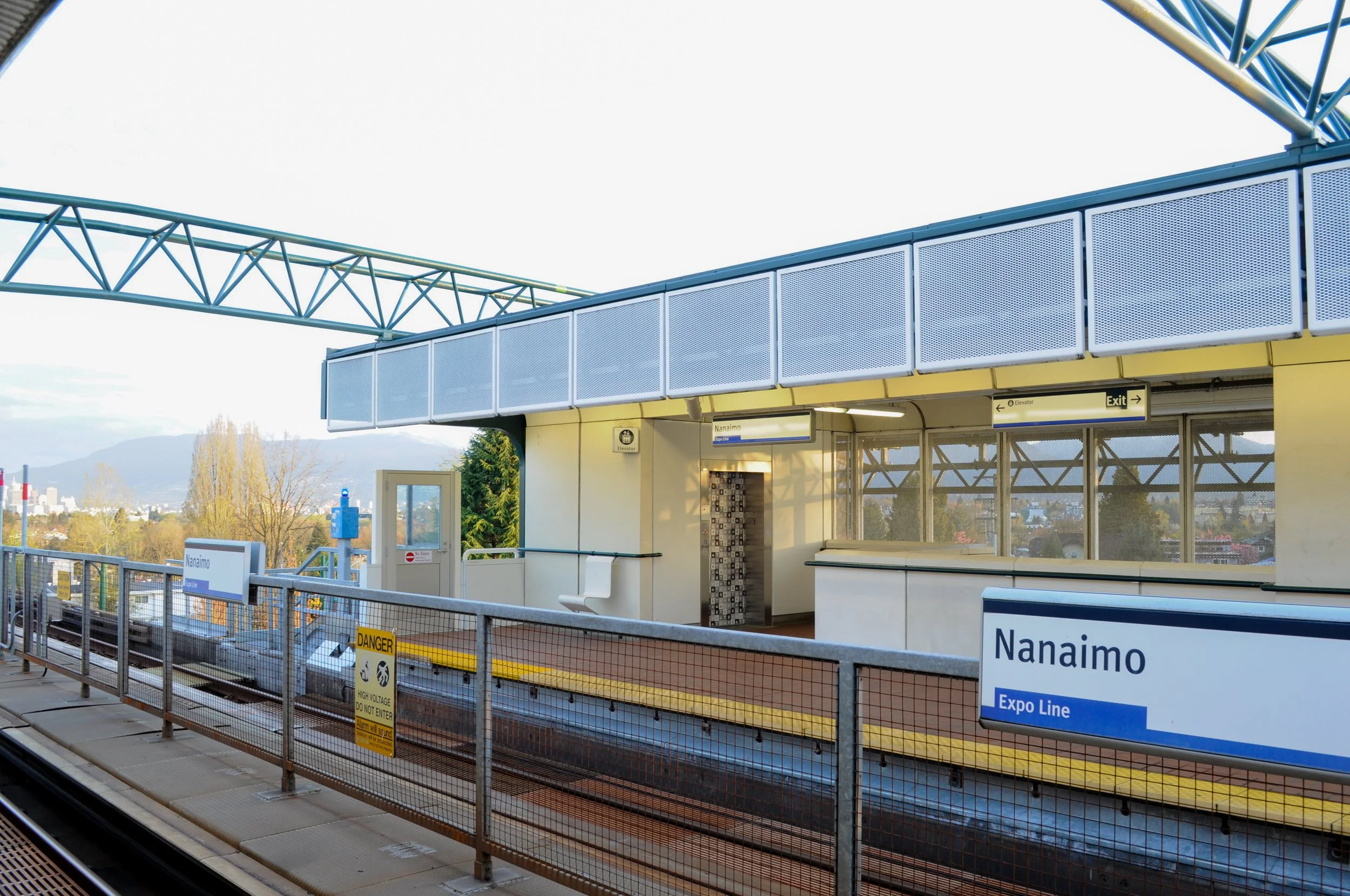 Platform view at Nanaimo SkyTrain Station with rail safety signage during station upgrades